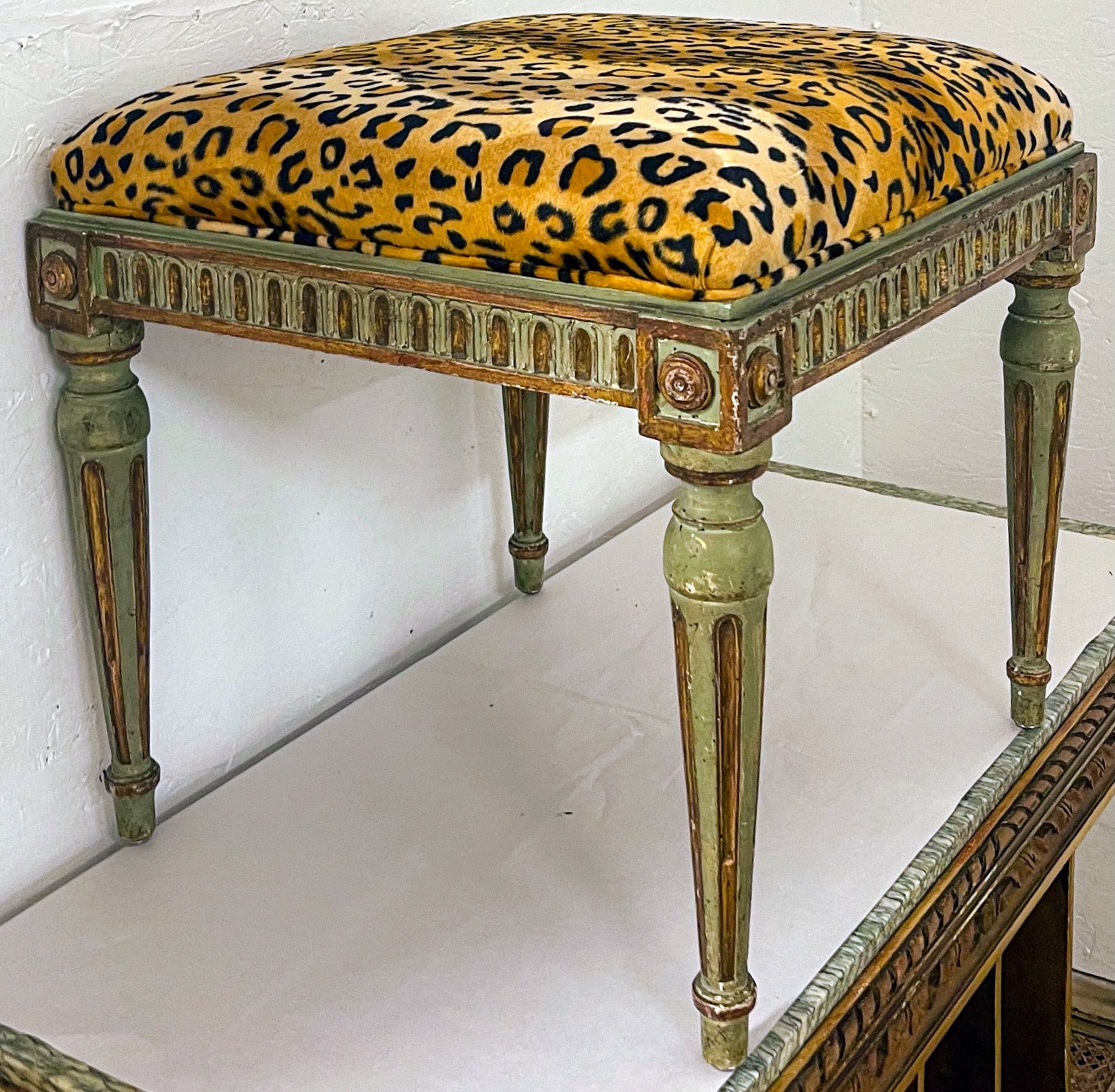 This is beautiful! It is a 19th century French green painted ottoman newly upholstered in leopard velvet. The green painted frame has gilt accents and shows age appropriate wear.