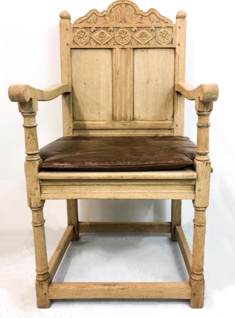 This is a pair of 19th century French bleached oak armchairs. The frames are heavily carved and in very good condition. The slim leather cushion is vintage and is also free from tears.