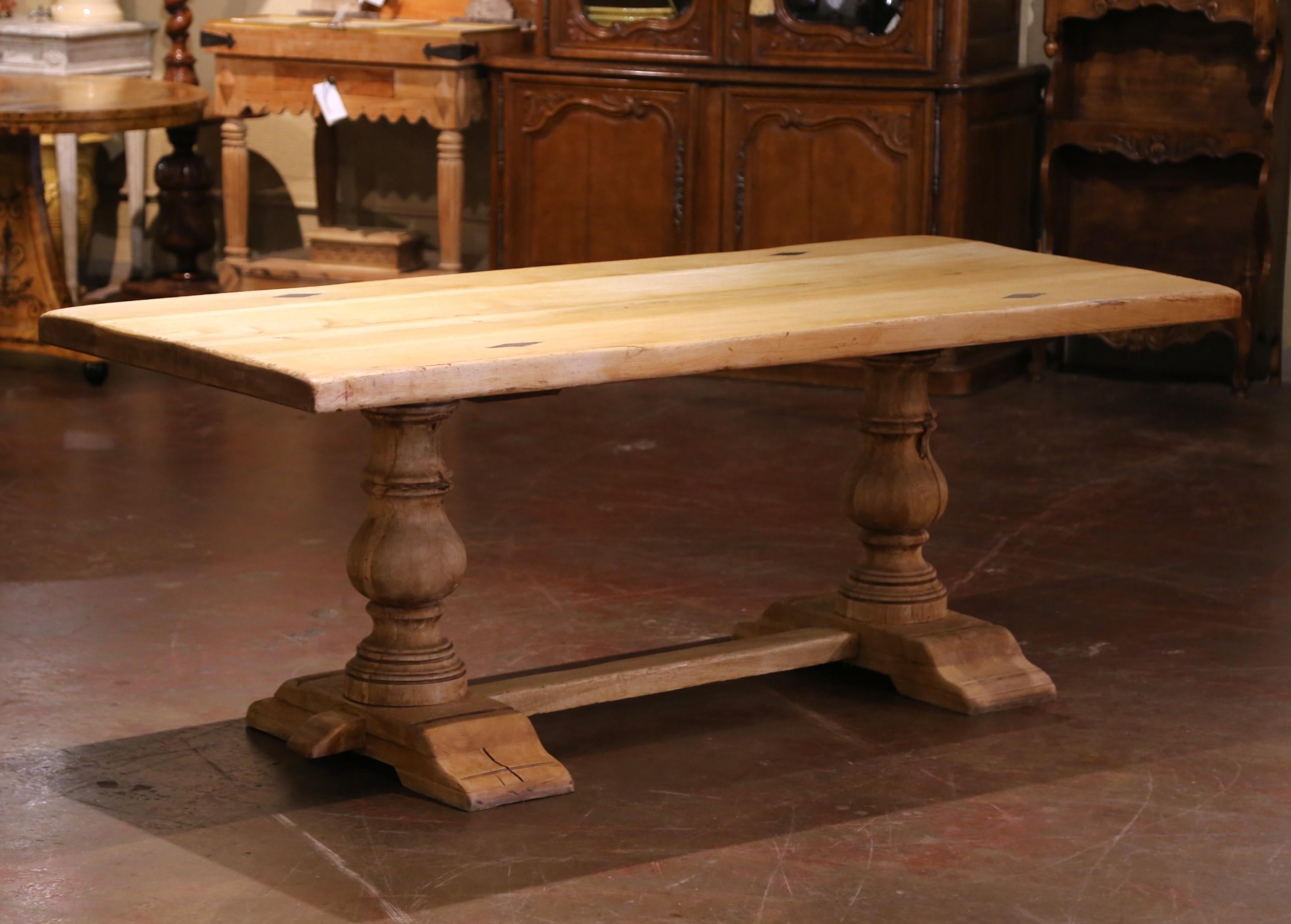 Dieser beeindruckende, um 1900 in Frankreich gefertigte Refektoriumstisch verkörpert die rustikale Eleganz der traditionellen Bauernmöbel. Die rechteckige Platte aus massiver Eiche ist aus dicken Bohlen gefertigt, die schön gebleicht sind, um die