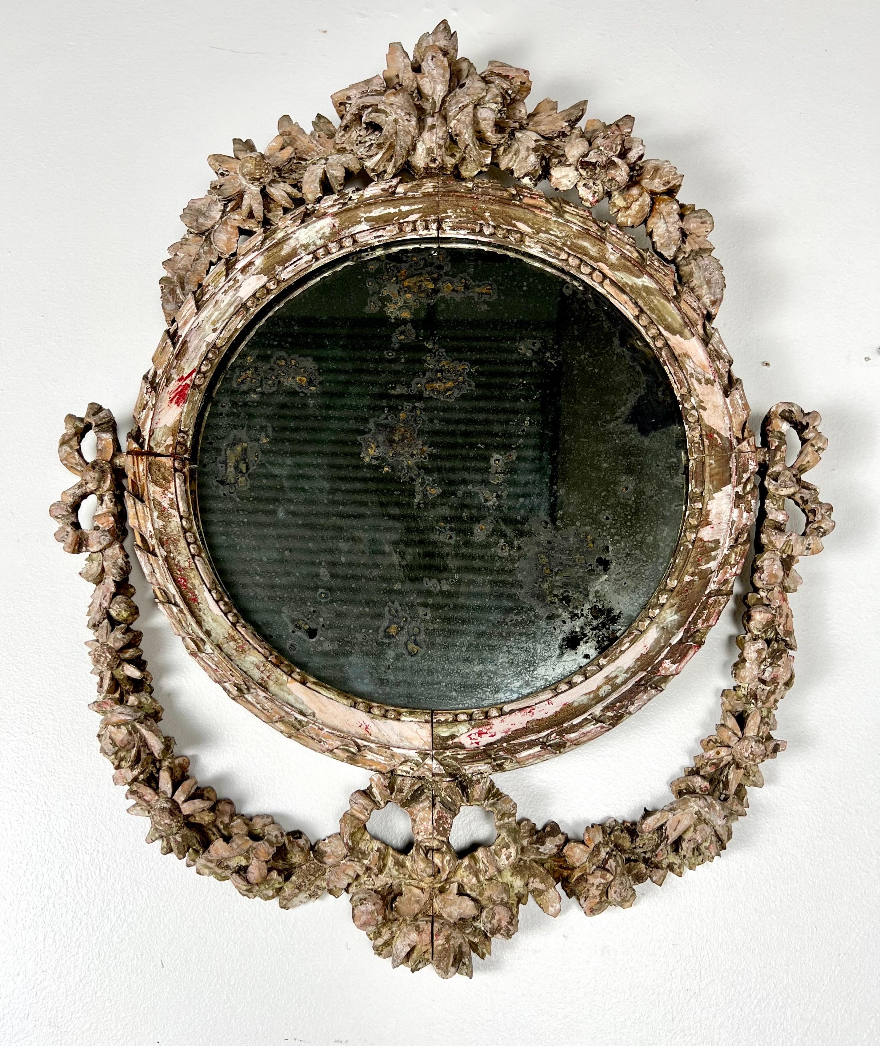 19th century Rococo carved mirror adorned with intricate floral motifs.  This mirror would be a great addition to any classical or vintage-inspired decor.  The craftsmanship and attention to detail during the Rococo period often resulted in timeless