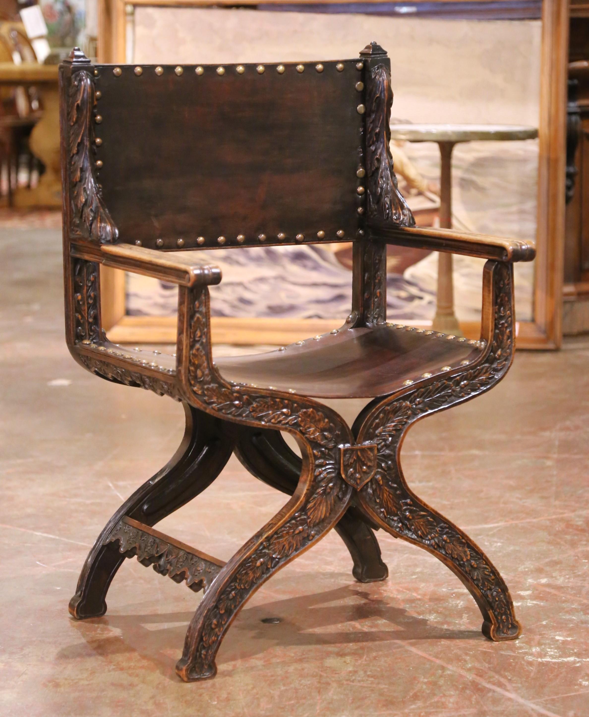 This striking 19th-century French armchair is a superb example of the curule or “Dagobert” style, inspired by early medieval throne designs and reinterpreted in the Renaissance Revival tradition. Hand-carved from solid walnut and richly patinated