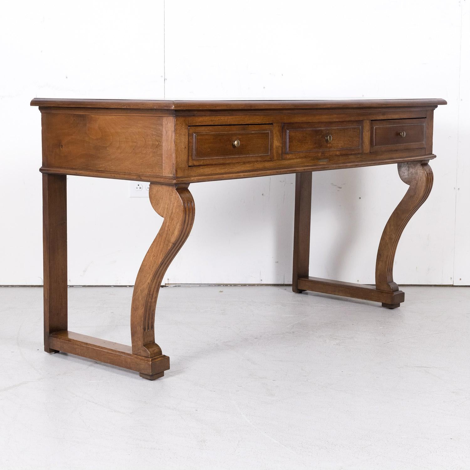 Handsome 19th century Charles X period wall console handcrafted of walnut in Lyon for the famous French parfumerie Vachon-Bavoux & Cie, circa 1820. A rectangular plank top sits above three drawers with the center drawer having the bronze plate