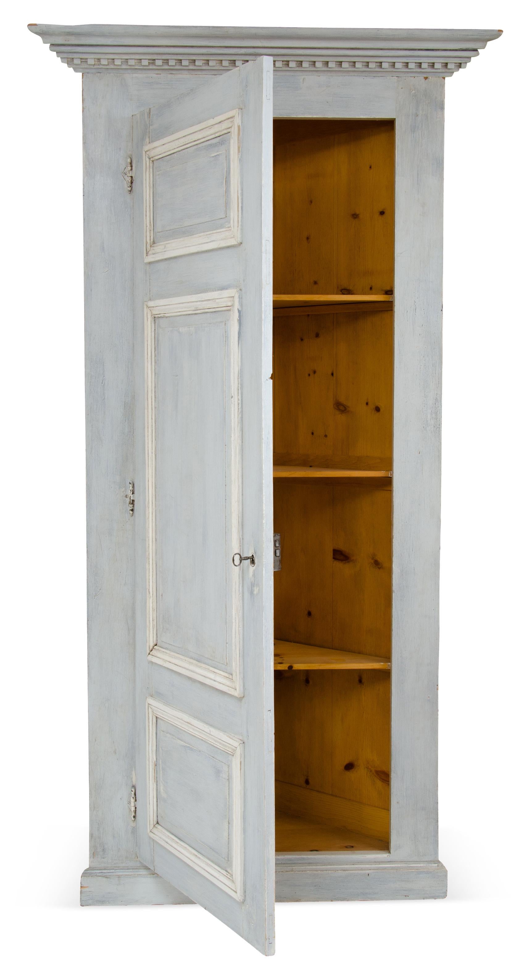 A single door painted French corner cabinet in the Louis XVI style. Made out of pine wood painted with light gray/blue and cream accents. Features beautiful molding and fluted detail. great piece for any room, ample storage and unique vintage piece.