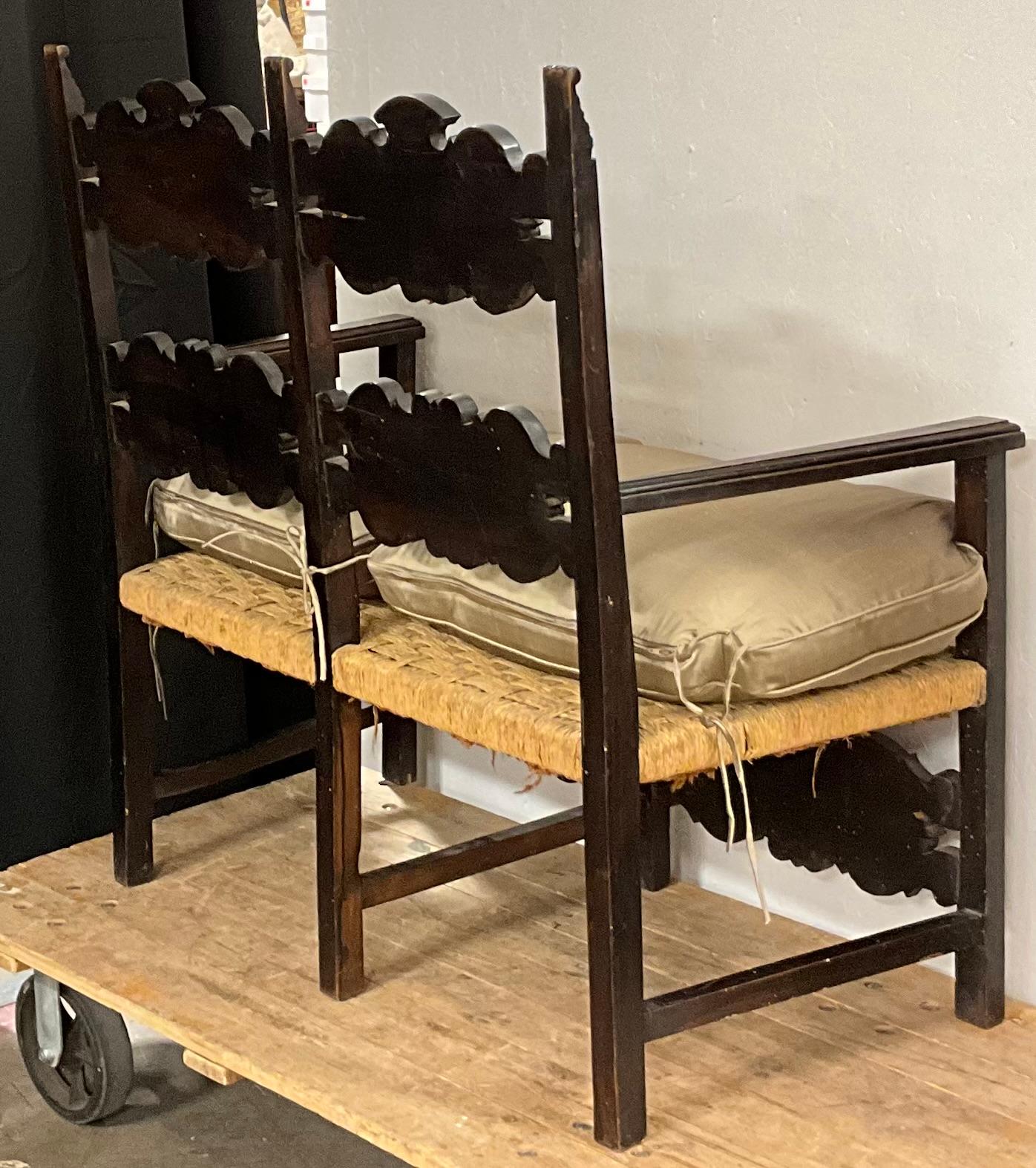 This is a rustic 19th century French ebonized carved oak settee with rush seat and plump down cushion. The silk fabric is in very good condition, and the rush shows slight wear. The arm height is 25 inches.



