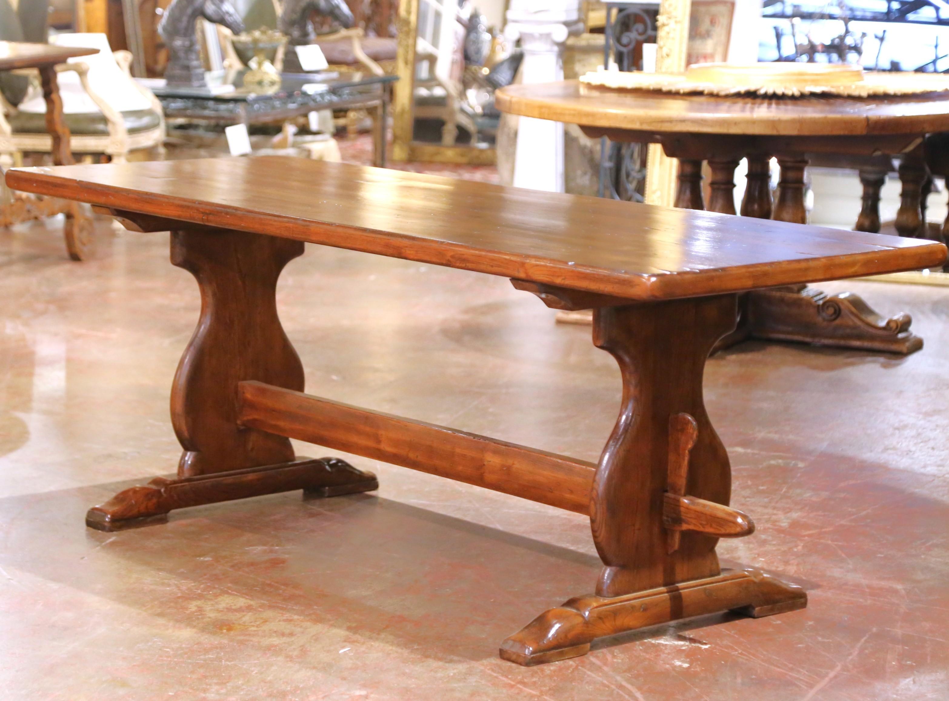 Fabriquée en France vers 1880, cette table de réfectoire ou de monastère antique est faite d'orme massif à la patine riche et chaude. Le plateau rectangulaire repose sur des supports en forme de tréteaux, chacun formé de courbes douces et se
