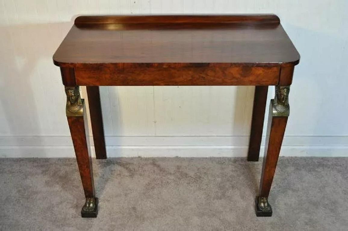 19th C. French Empire Crotch Mahogany Bronze Ormolu One Drawer Console Hall Table. Item features beautiful wood grain with attractive mounts including human form feet, rear back splash, and maiden heads supporting the one drawer top surface. Circa