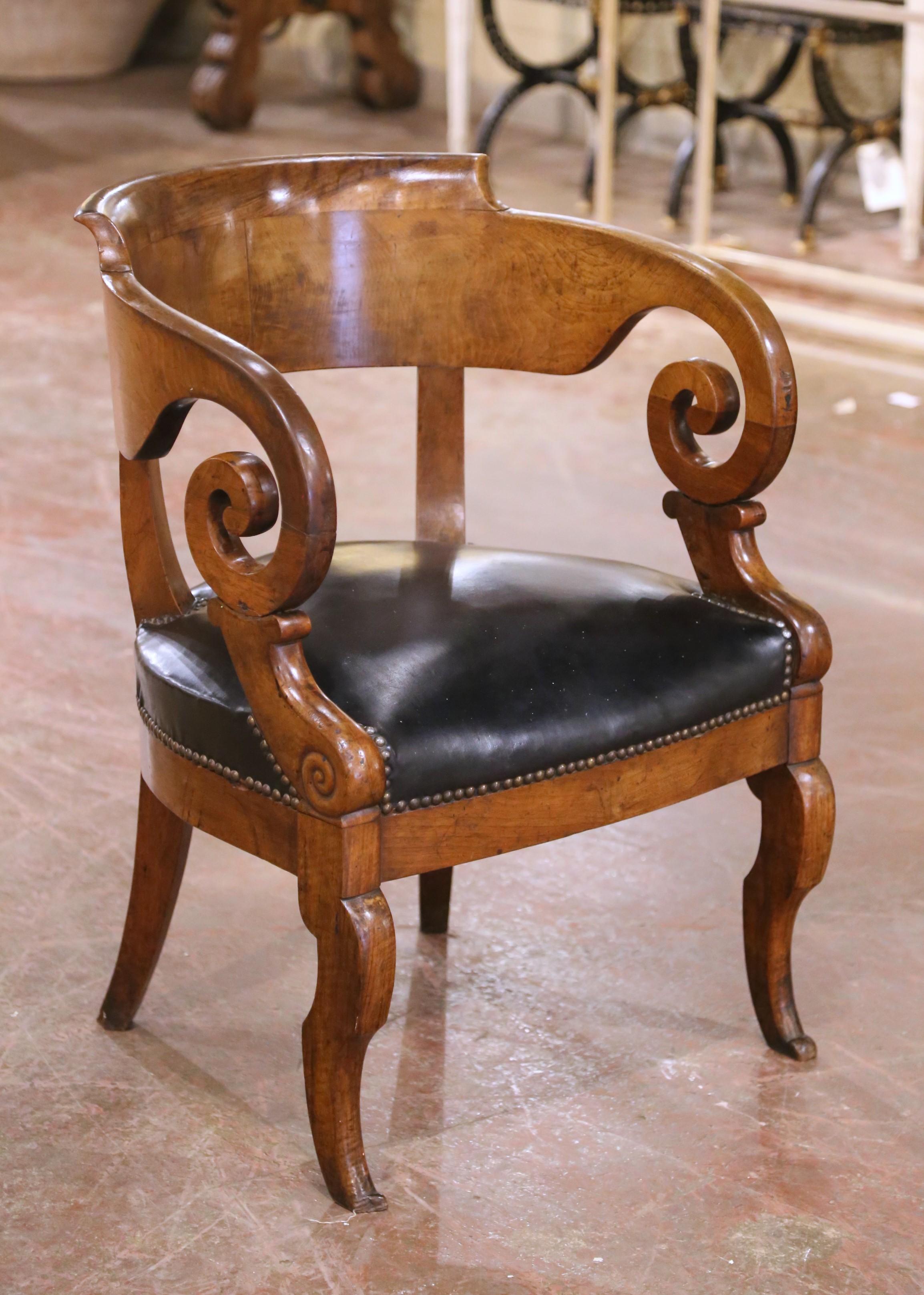 Esta elegante silla de escritorio Imperio francés del siglo XIX, tallada hacia 1870, presenta un escultural armazón de caoba con una rica y cálida pátina y líneas neoclásicas clásicas. El respaldo en forma de tonel está graciosamente curvado y fluye