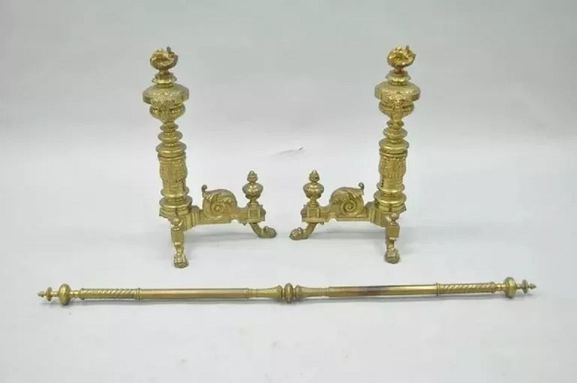 Paire d'andirons et de barres en laiton avec flamme et lion, de style néoclassique empire français du 19e C. Cet article présente une paire de chenets en laiton moulé ornés de fleurons à flamme, montés avec des têtes de lion et des anneaux de chute,