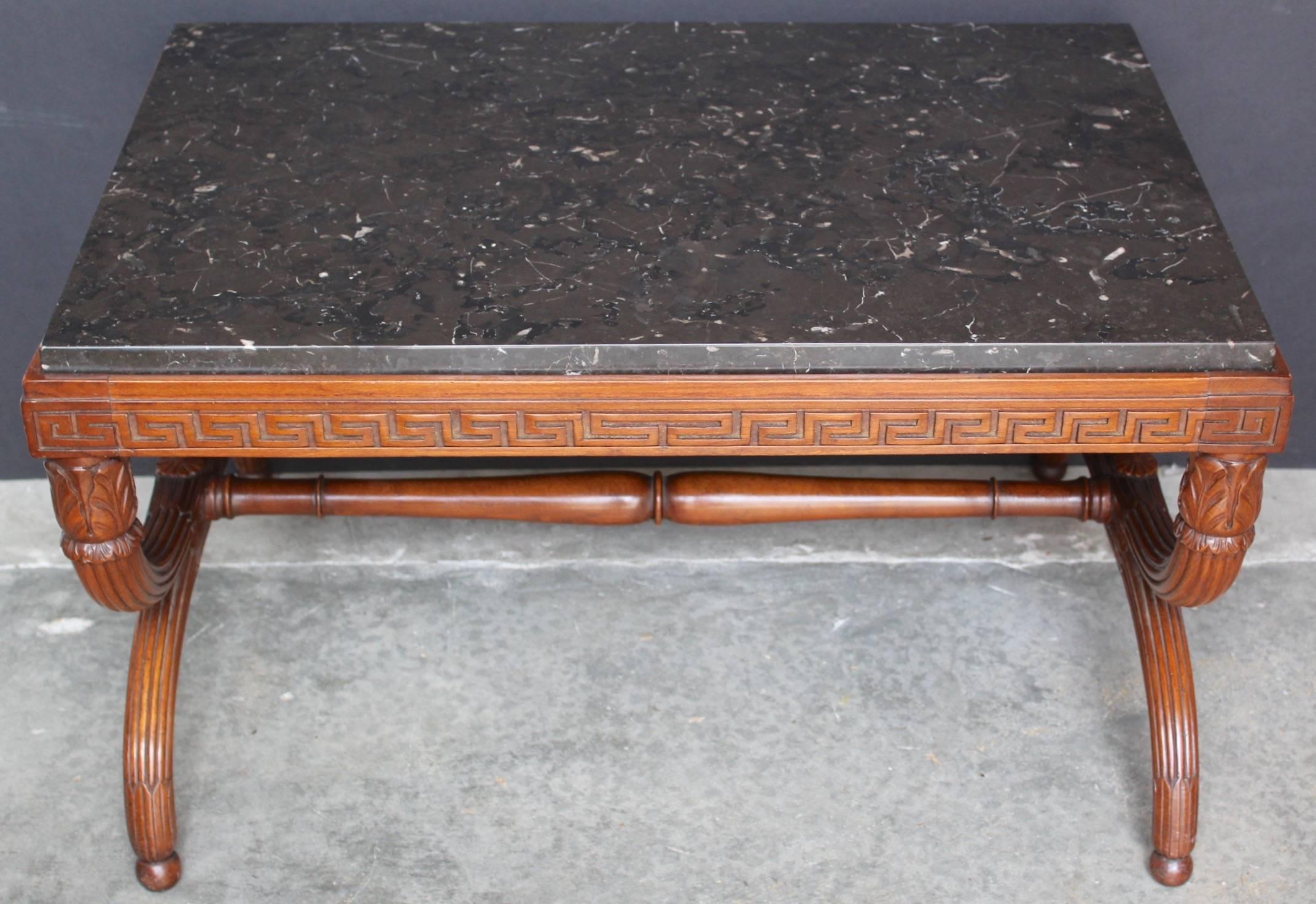 Remarkable Quality for this low-or coffee-table having fully hand-carved solid mahogany. The two supports are in X-shape and joined by a turned stretcher. The four feet are carved with a ' feuille d'eau 