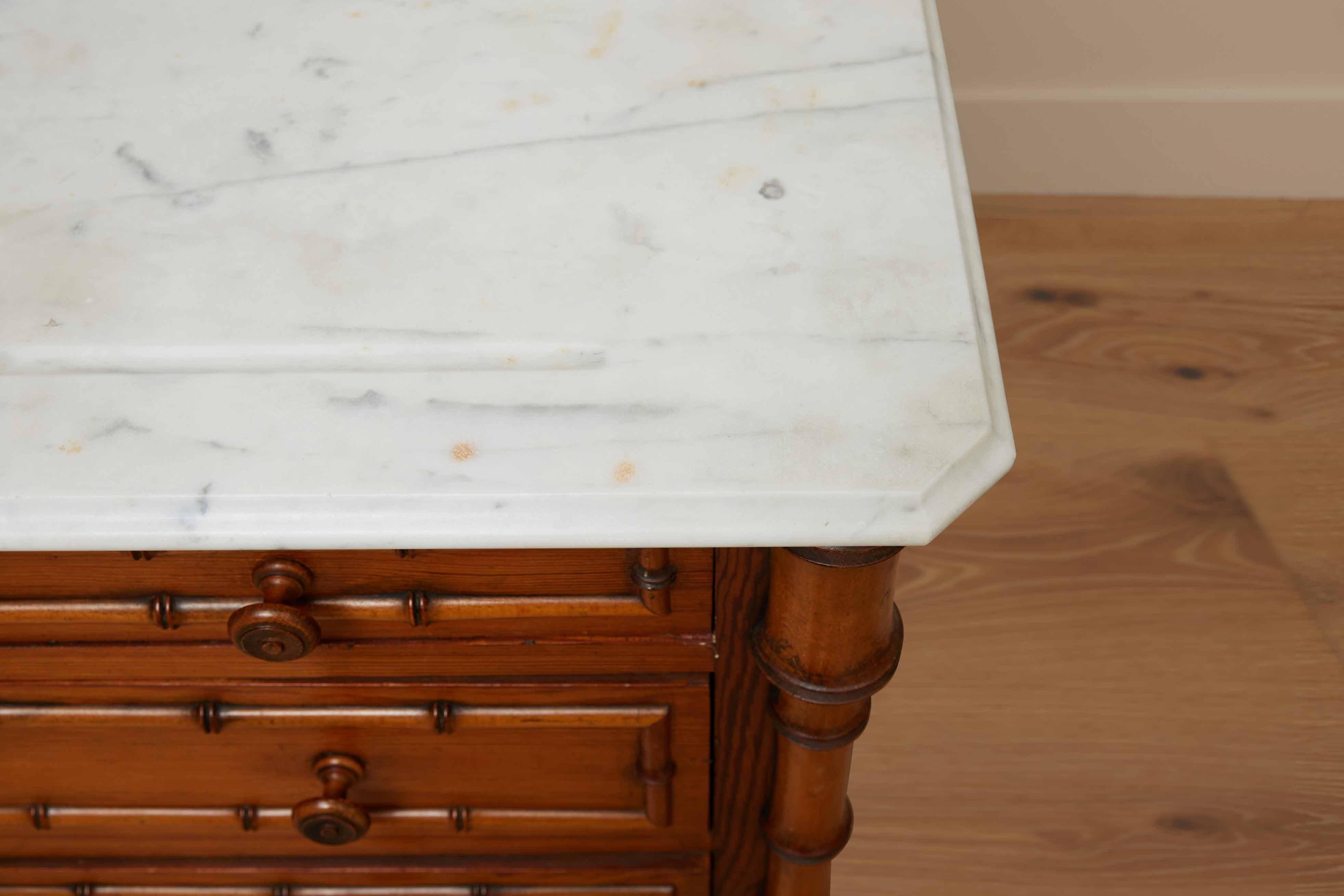 This exquisite late 19th-century French commode is a testament to the elegant aesthetic movement that captivated the era. Crafted from the finest pitch pine, this piece exudes timeless charm and sophistication. Its standout feature, a pristine white