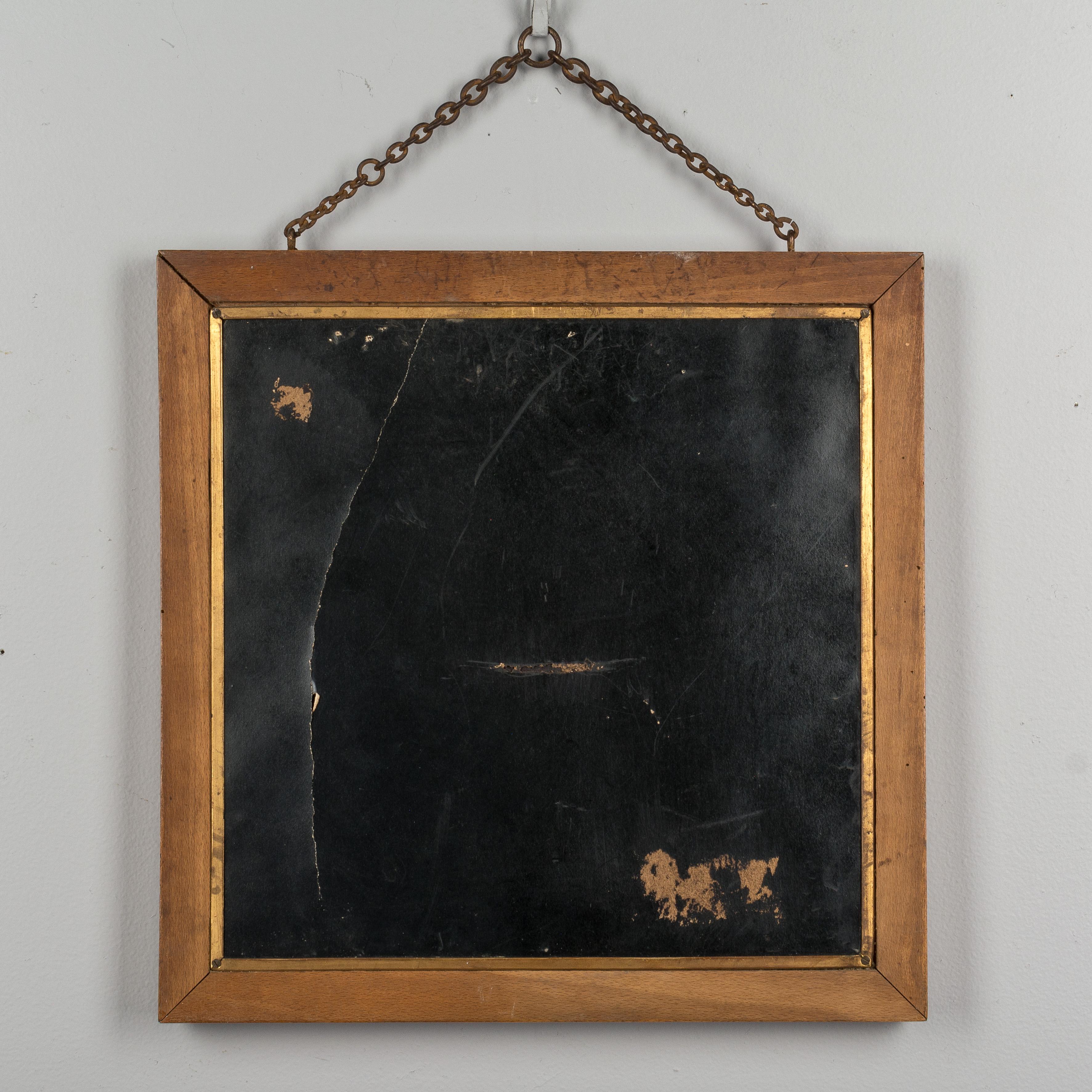A 19th century French tri-fold shaving mirror with faux bamboo framed door panels made of beechwood and a small chain for hanging on the wall. The panels are faced with decorative Japanese paper prints depicting two figures and a pair of cranes.