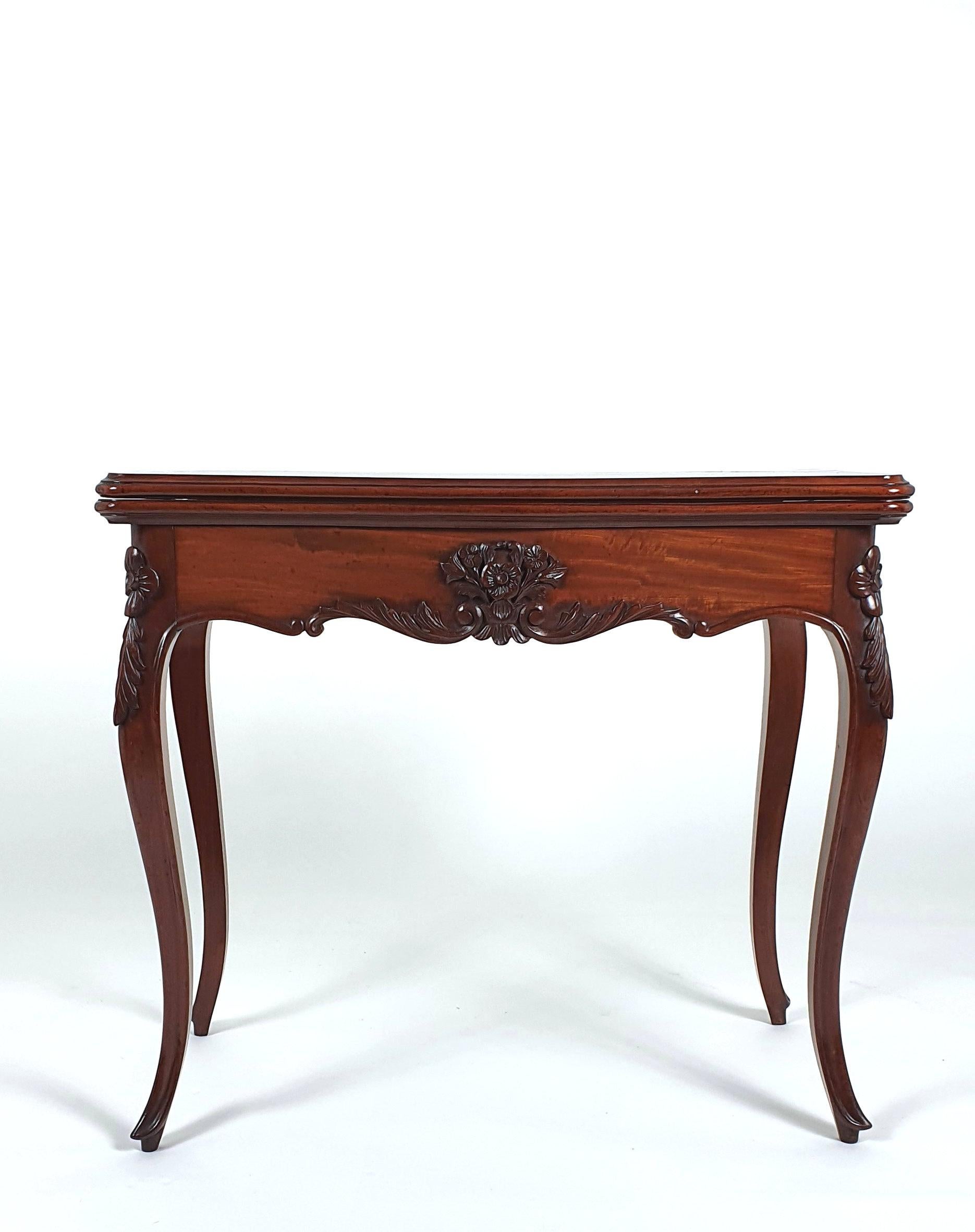 This elegant and very good looking 19th century French figured mahogany fold over card table stands on delicate cabriole leg supports with a carved floral decoration and a concertina action. The table has a green baize lined interior with a space