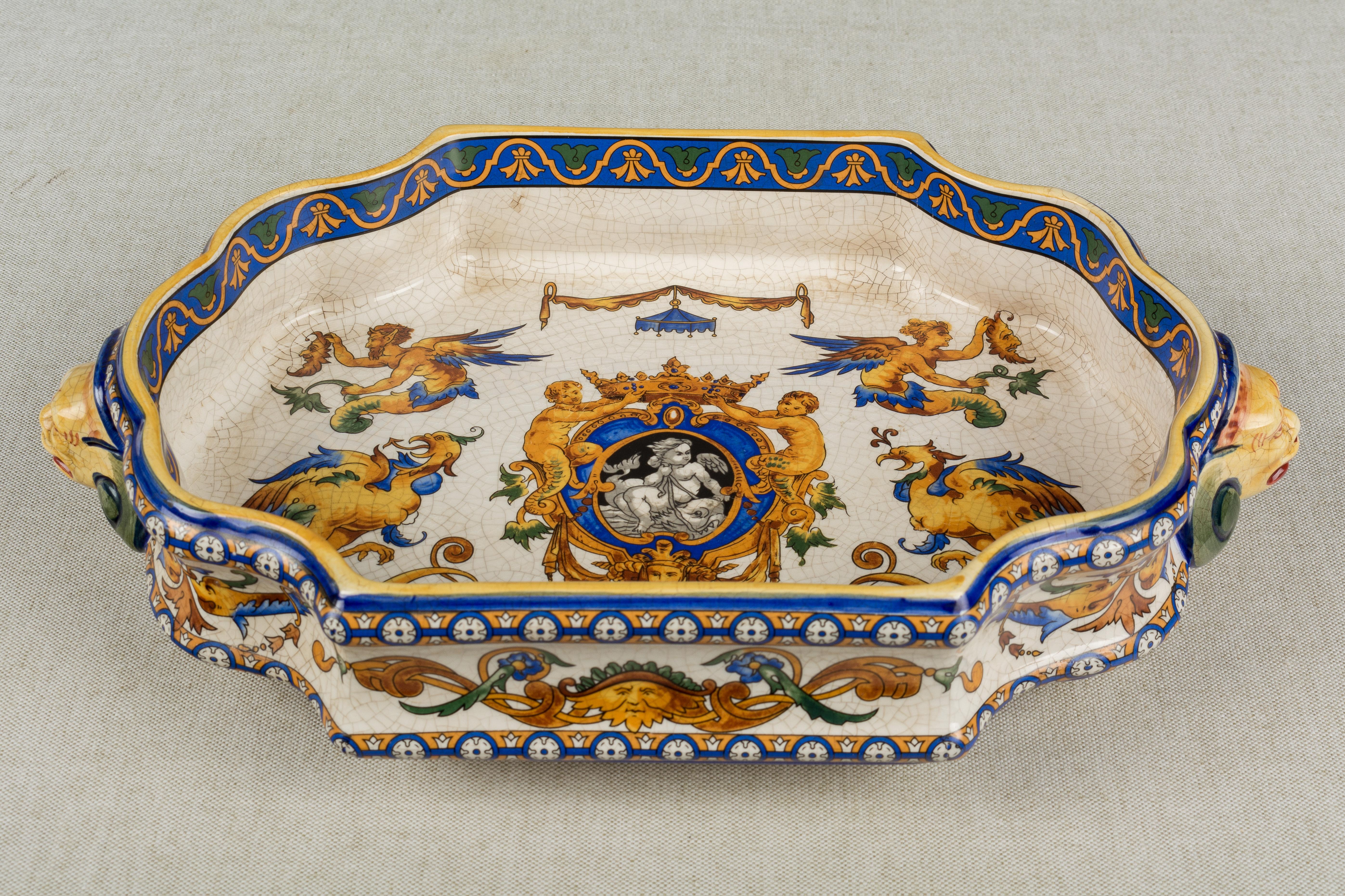 A 19th century French Gien faience ceramic jardinière, or shallow footed centerpiece bowl. Hand painted in orange, yellow, green and blue with Renaissance style imagery including a central medallion with crown flanked by a pair of phoenix, or winged