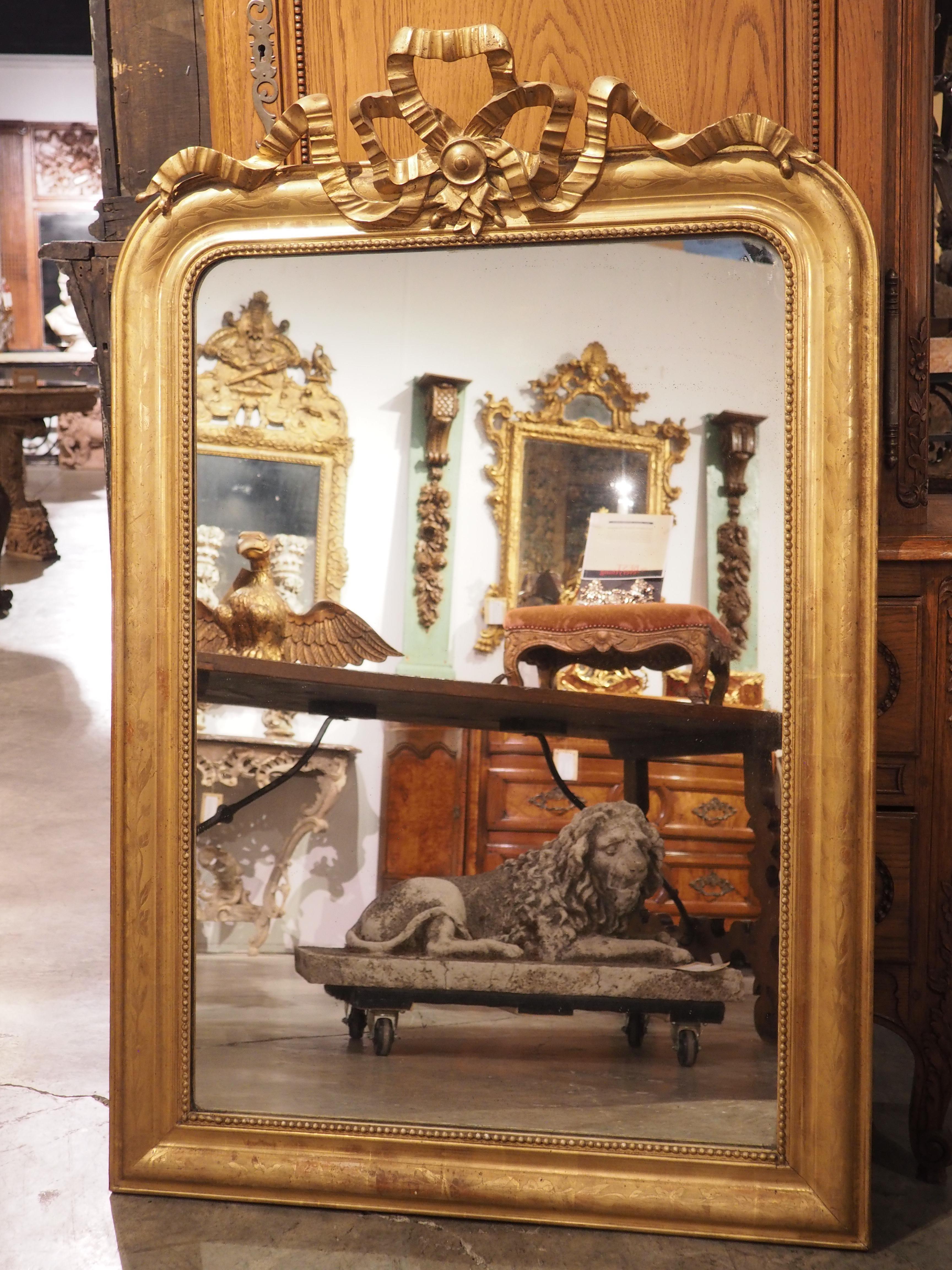 Mirrors produced during the Louis Philippe period are typically rectangular with rounded upper corners and square bottom corners, as seen on this lovely mirror. Hand-carved in France in the mid-1800’s, the surrounding gold frame has characteristics