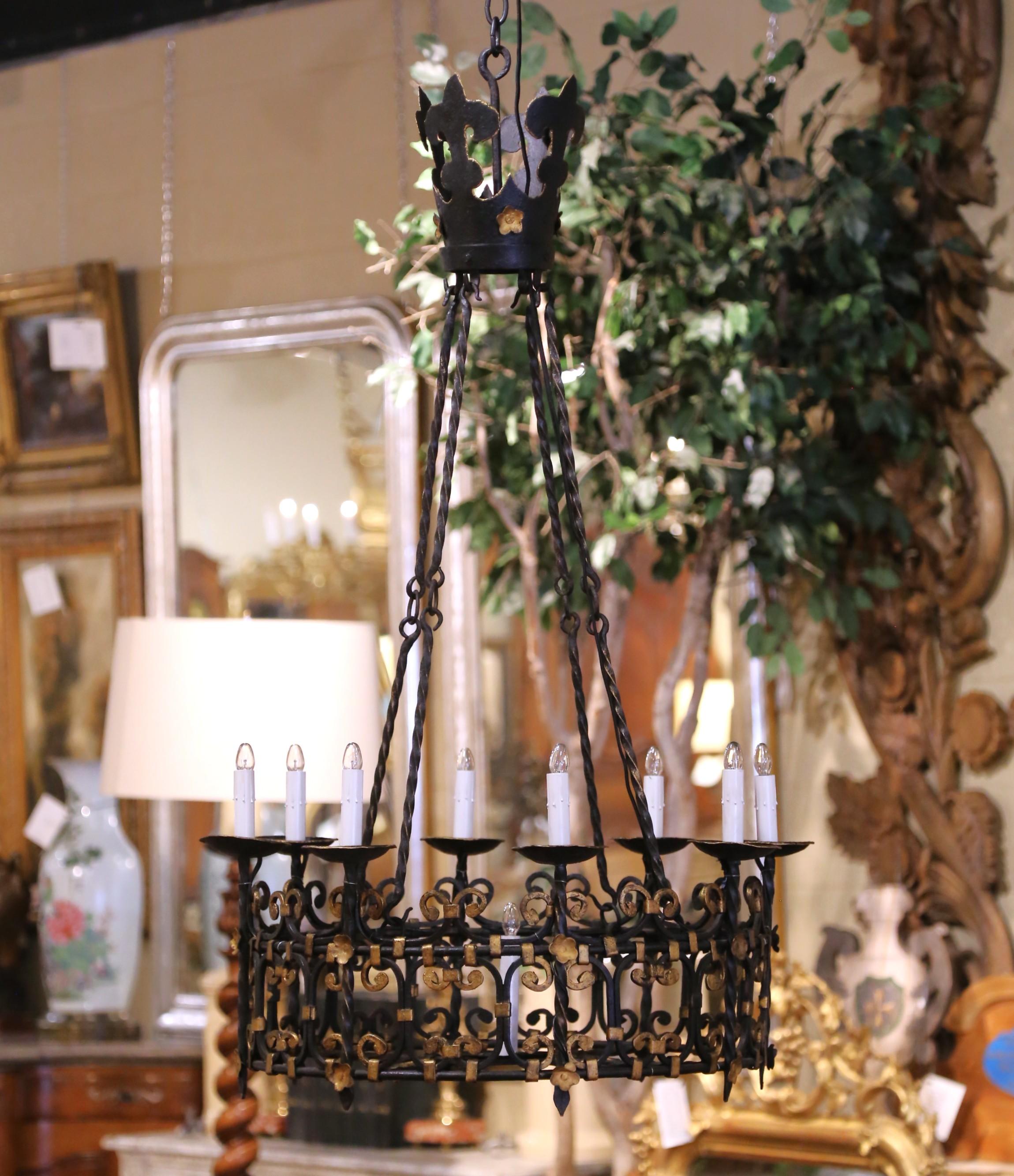 Illuminate your dining room, library, or entryway with this striking antique French chandelier. Crafted in France circa 1870, the fixture is forged from hand-wrought iron and designed in a bold Gothic style. The circular frame is decorated with