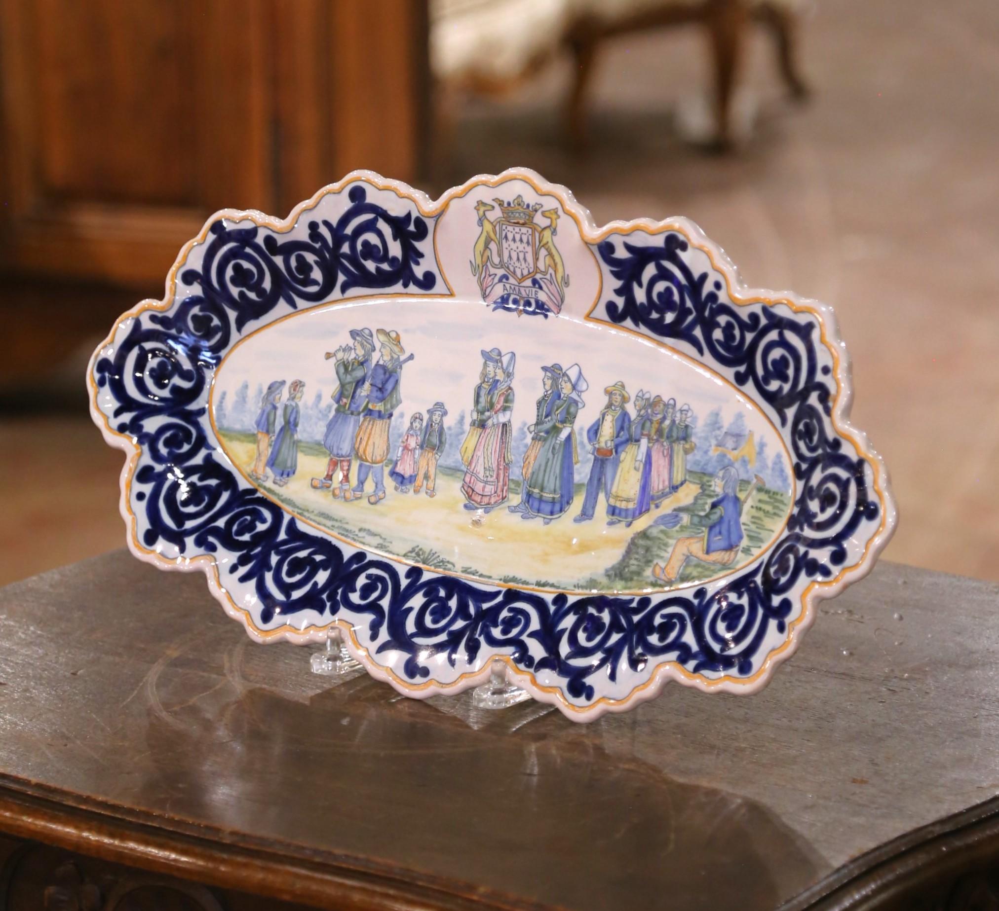 Placa mural decorativa de la célebre faïencerie Henriot de Quimper (Bretaña), datada hacia 1880. Esta placa oval alargada, que mide 29,25 pulgadas de ancho por 10,5 pulgadas de alto, está pintada a mano con una vibrante escena de danza folclórica