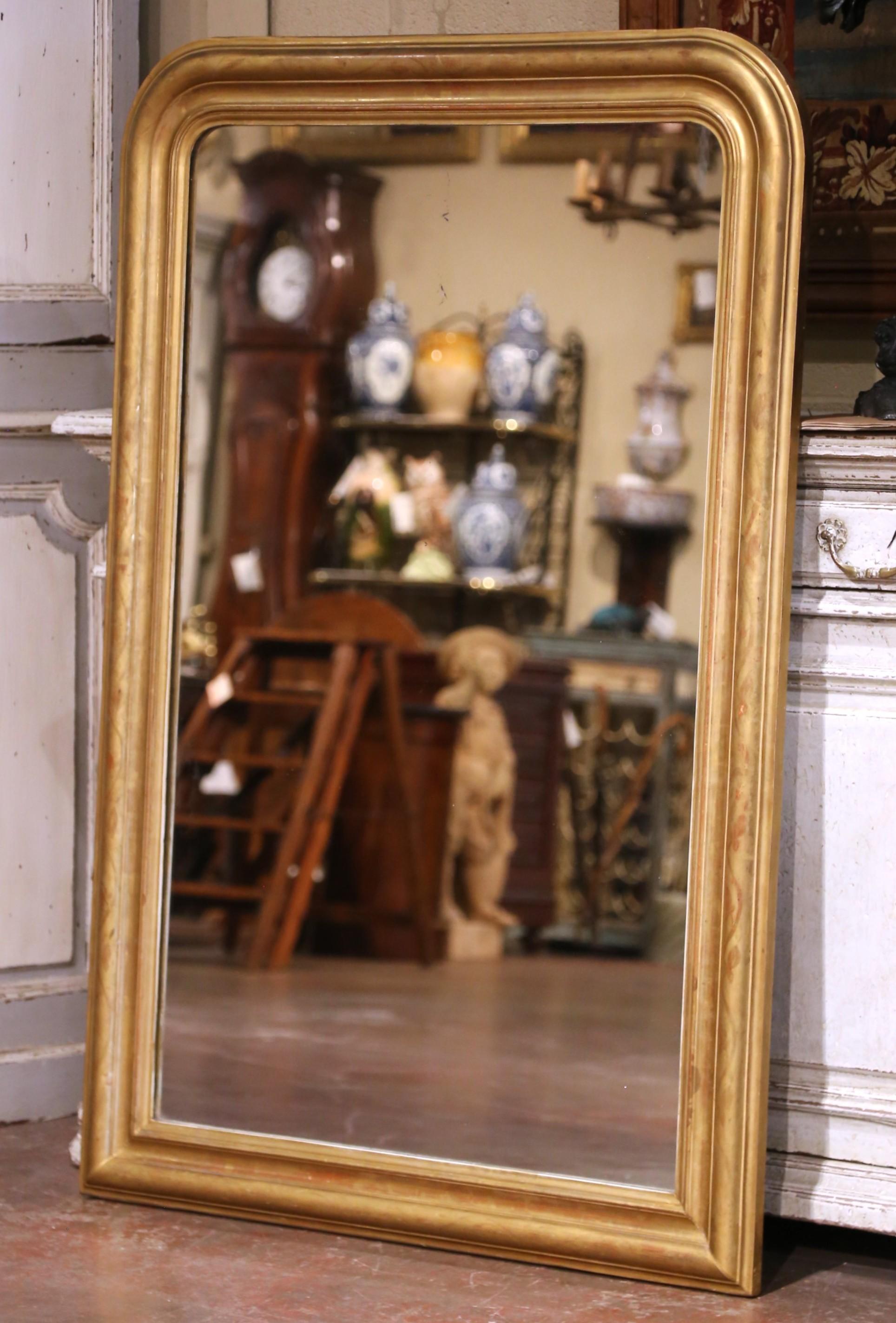 Un élégant miroir ancien Louis Philippe de France, fabriqué vers 1870. Cette décoration murale du XIXe siècle présente un cadre en bois doré sculpté avec des coins supérieurs arrondis et un profil subtilement étagé, fini dans sa feuille d'or
