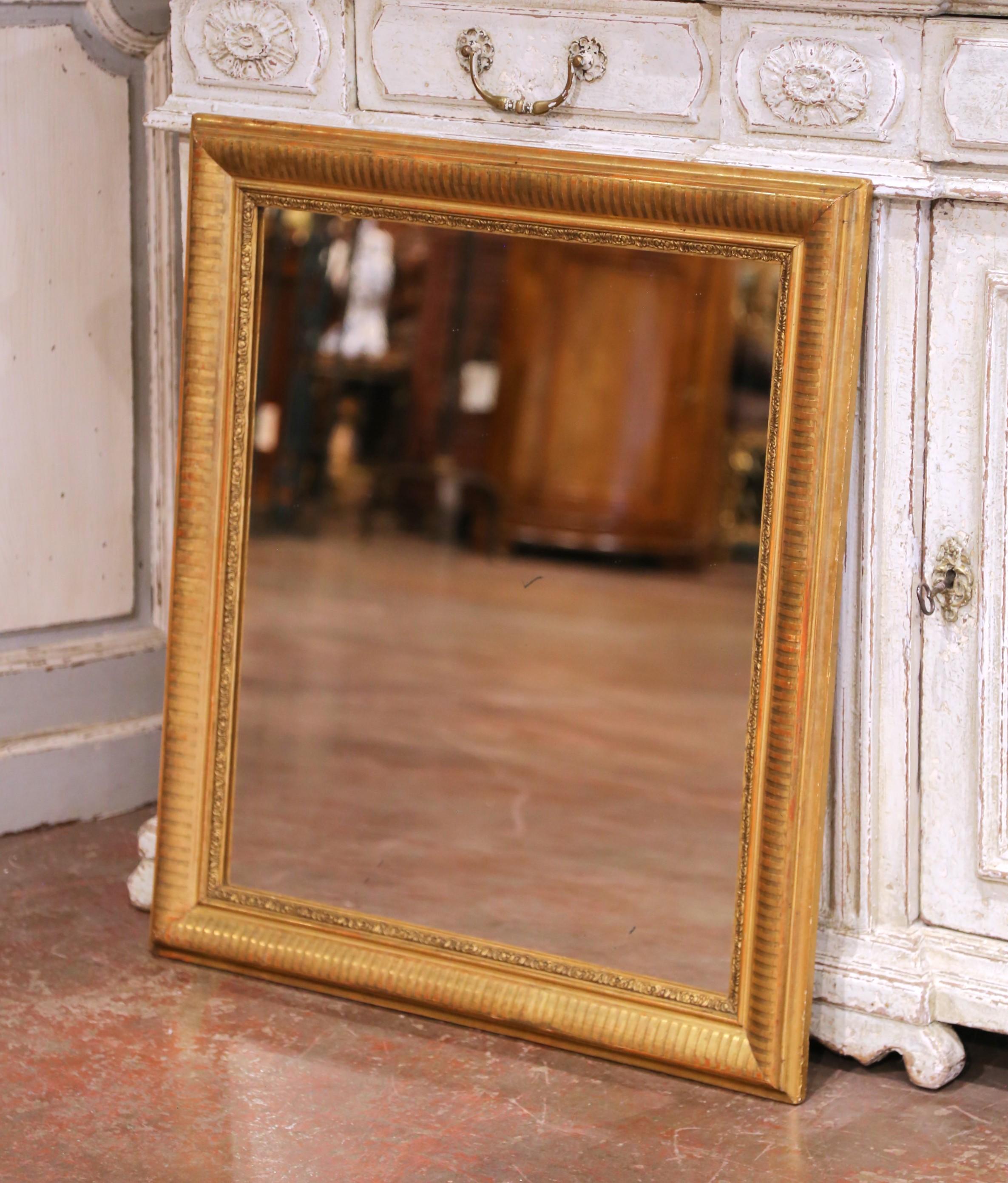Elegant et polyvalent, ce miroir ancien Louis Philippe a été fabriqué vers 1870 et présente un cadre classique en bois doré aux lignes pures et sobres. La silhouette presque carrée est accentuée par un motif de rayures verticales sur la moulure