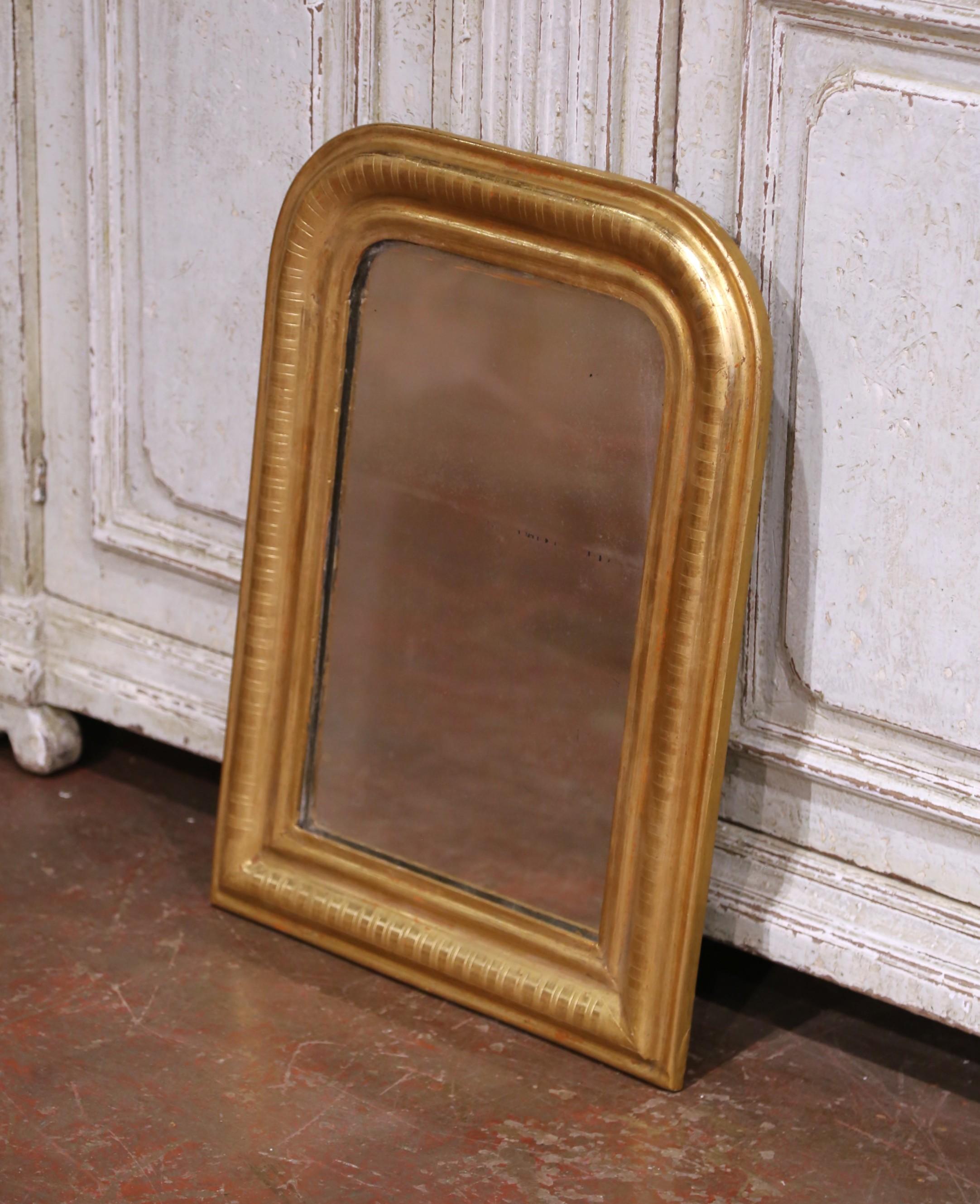 Decora un tocador o un recibidor con este espejo de pared antiguo de madera dorada. Fabricado en la región francesa de Borgoña hacia 1870, el pequeño espejo tiene líneas tradicionales con esquinas redondeadas; la decoración rectangular de pared está