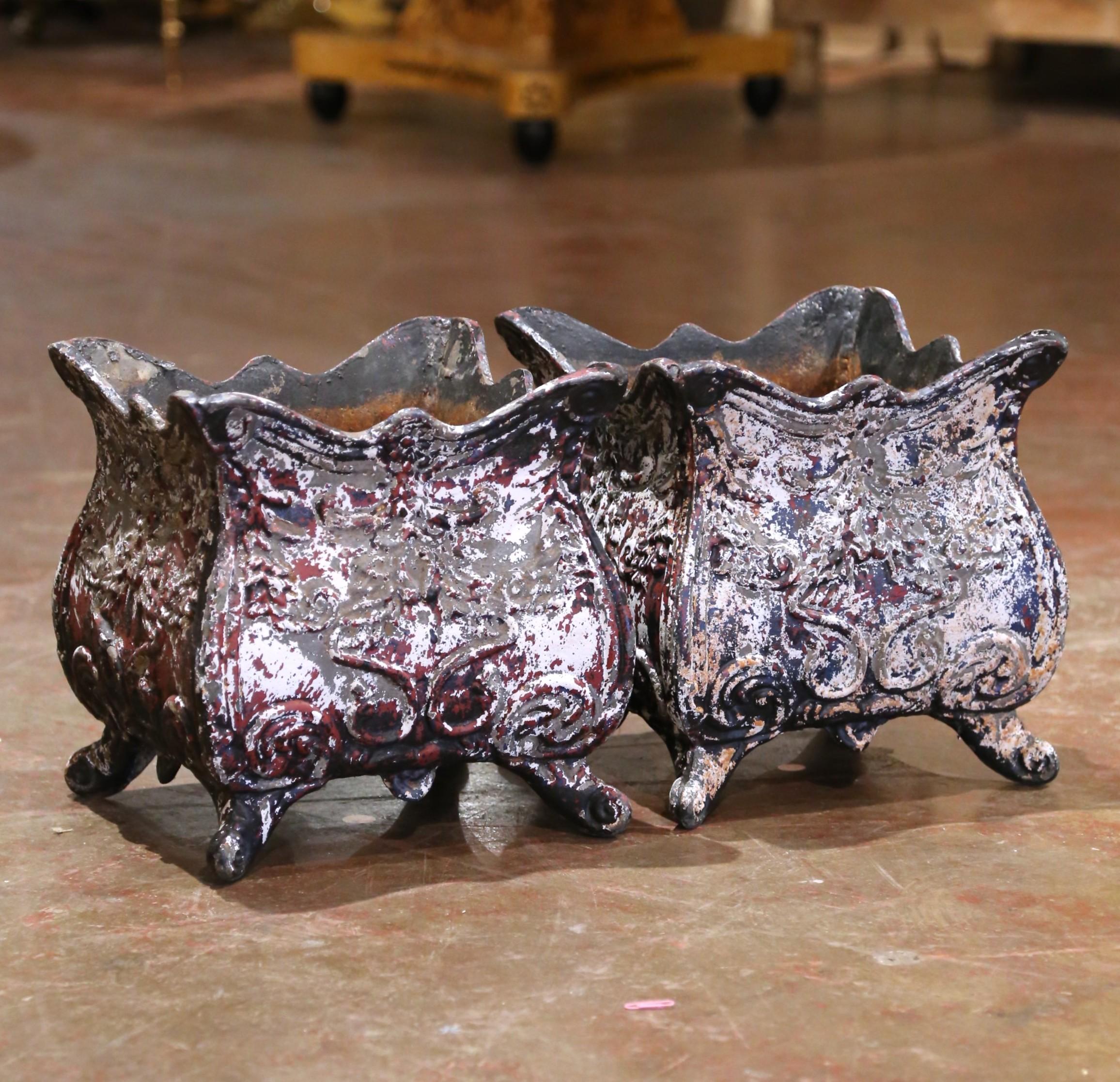 Fabriquée en France vers 1870, cette paire de jardinières en fonte reflète les courbes gracieuses et les motifs feuillagés ornementaux caractéristiques du style Louis XV. Chacun d'entre eux présente un corps en forme de bombe posée sur des pieds à