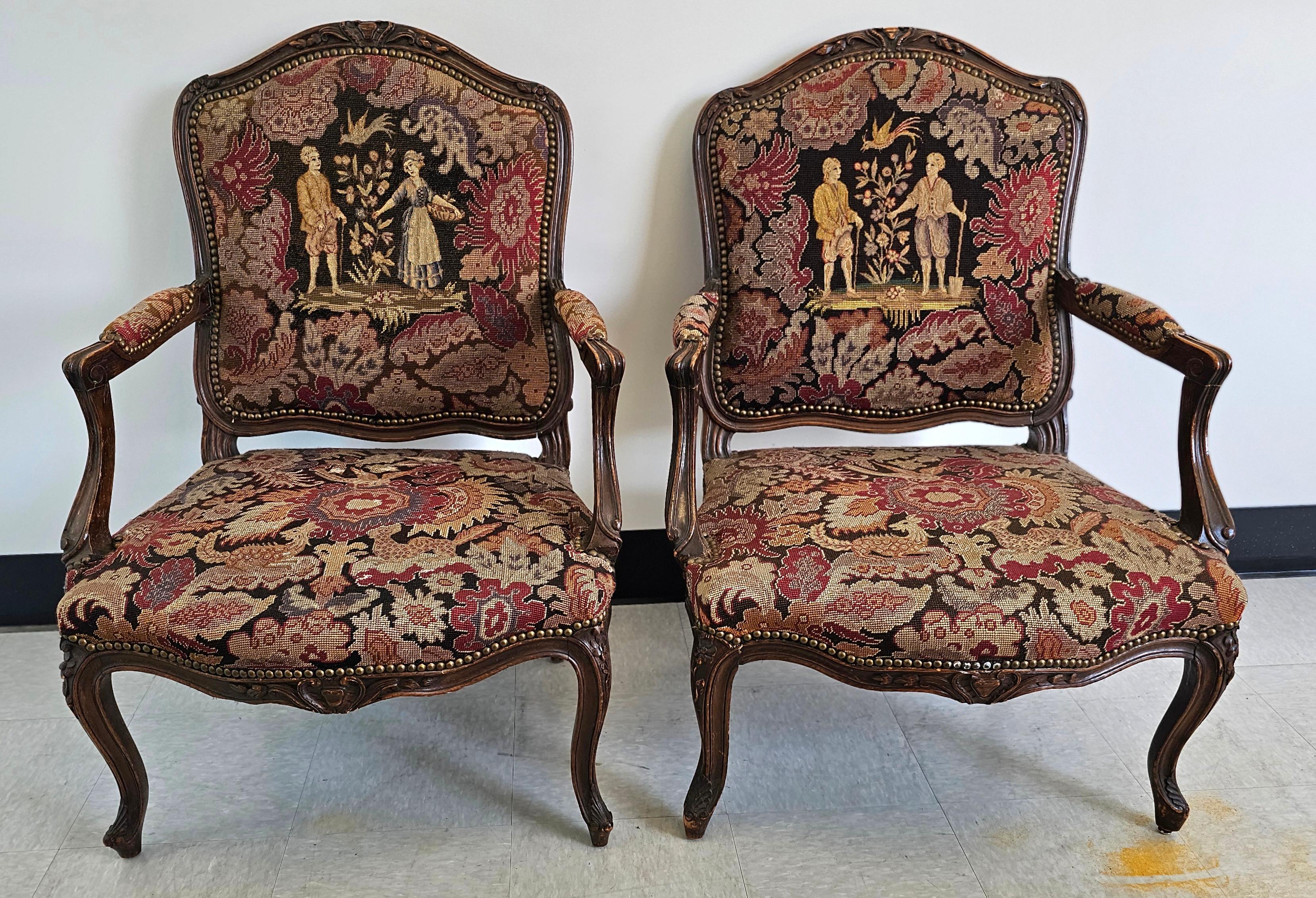 This pair of French Louis XV style Fauteuils features walnut frame with carved foliate, floral and scroll decoration; upholstered in pictorial needlepoint tapestry depicting courting scene in garden setting; 19th century.
Measures 28