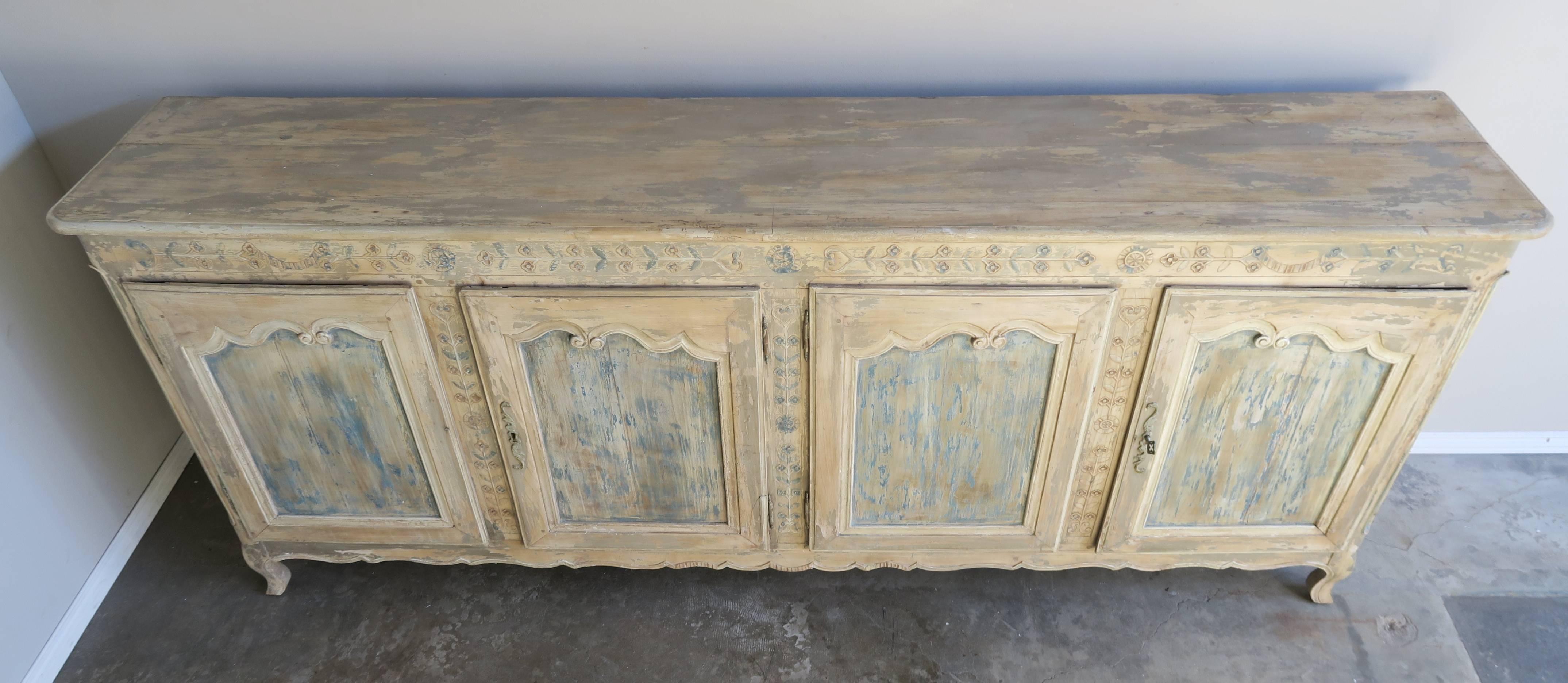 19th century French Louis XV style carved walnut buffet with a beautiful worn painted finish. The buffet stands on six legs, cabriole shaped legs in the front. There are four doors with original antique hardware.