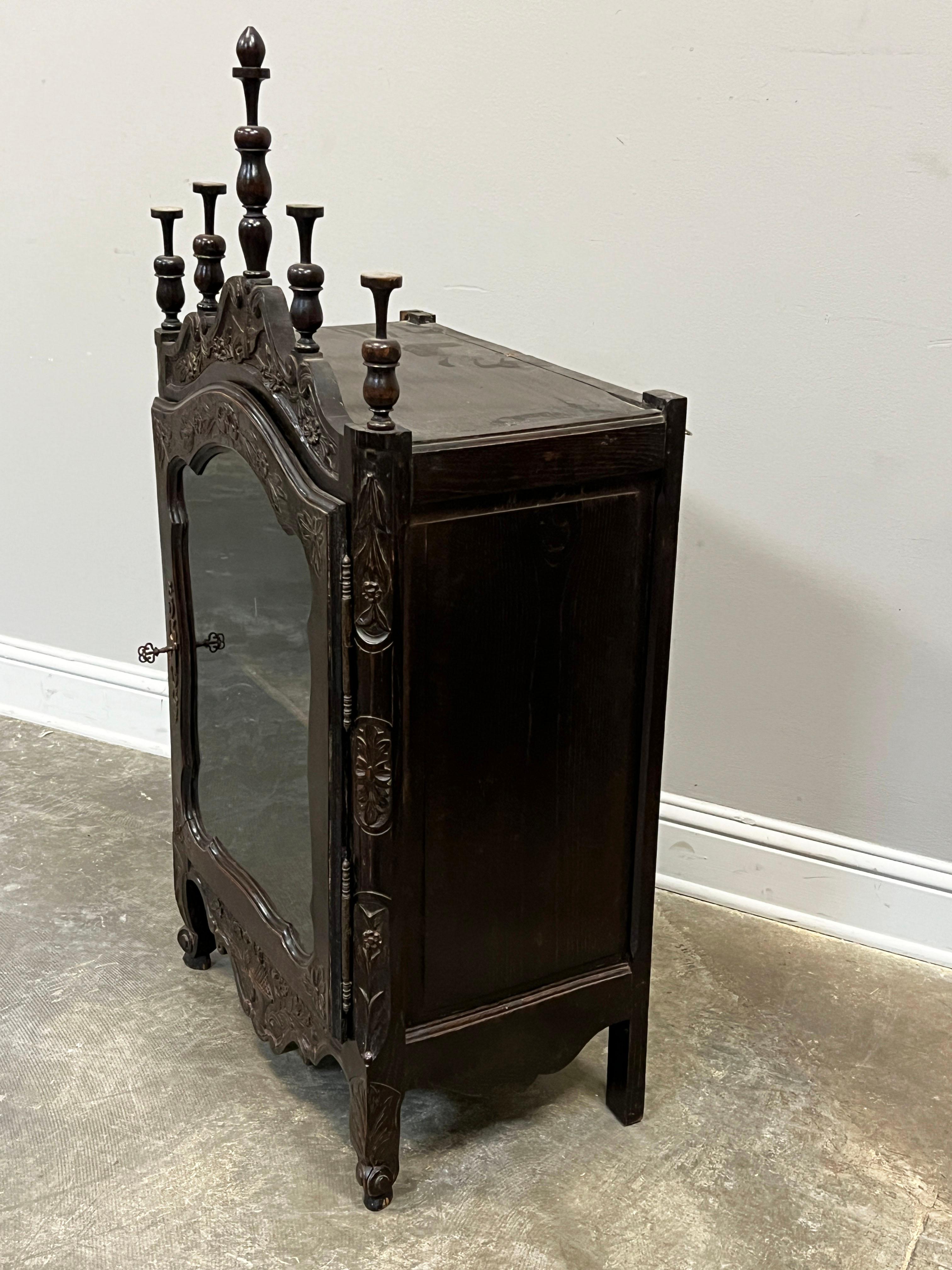 19th C. French Louis XV style hand carved vitrine in oak with original glass. Hand carved decorations indicative of the Louis XV style along with the cabriole legs. Five removable finials and one adjustable shelf. Vitrine can stand on its four legs