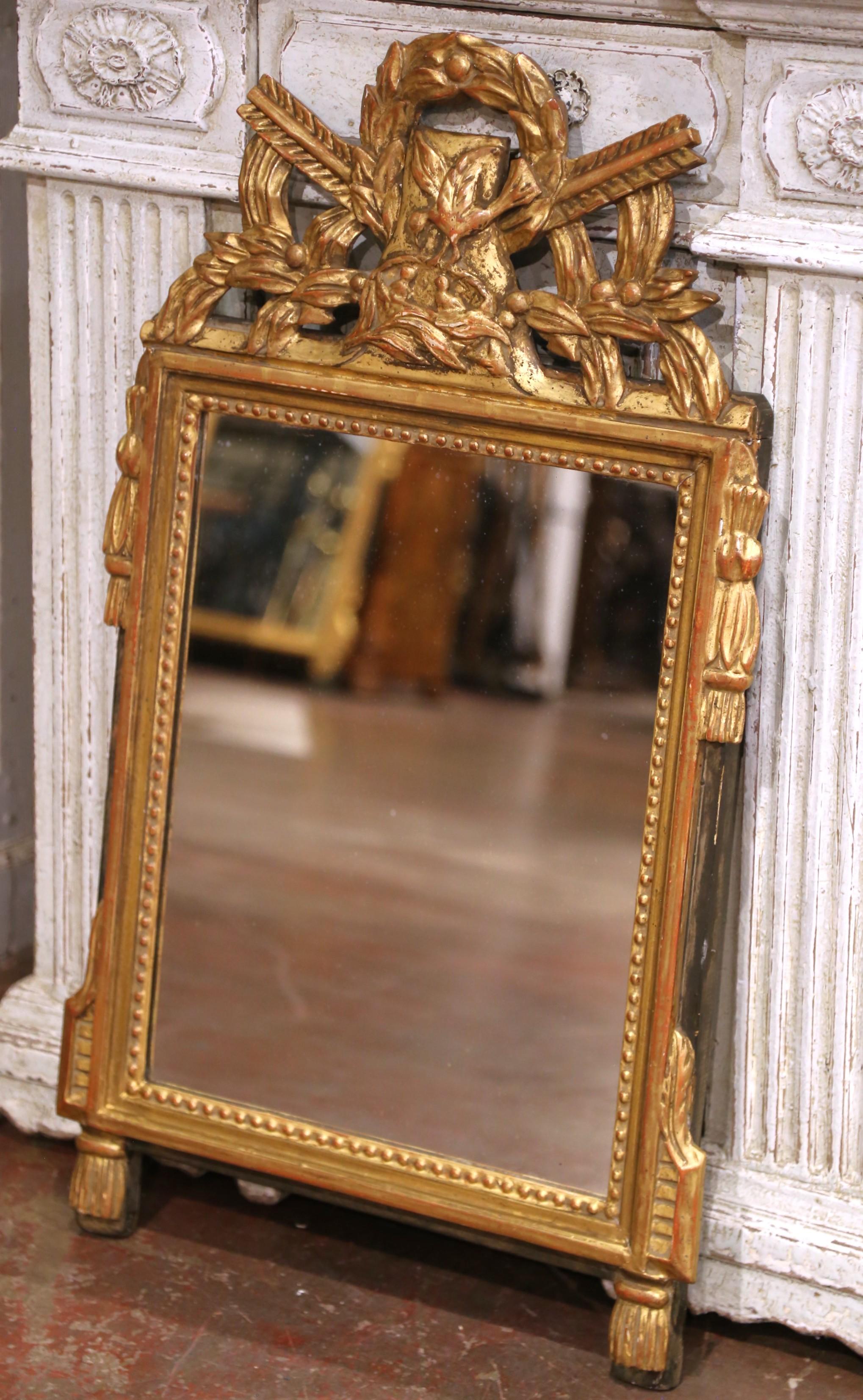 Decorate a powder room or entryway with this stately antique mirror, crafted in France circa 1880 in the neoclassical Louis XVI style. The rectangular giltwood frame is crowned with a boldly carved cartouche featuring a crossed quiver and torch