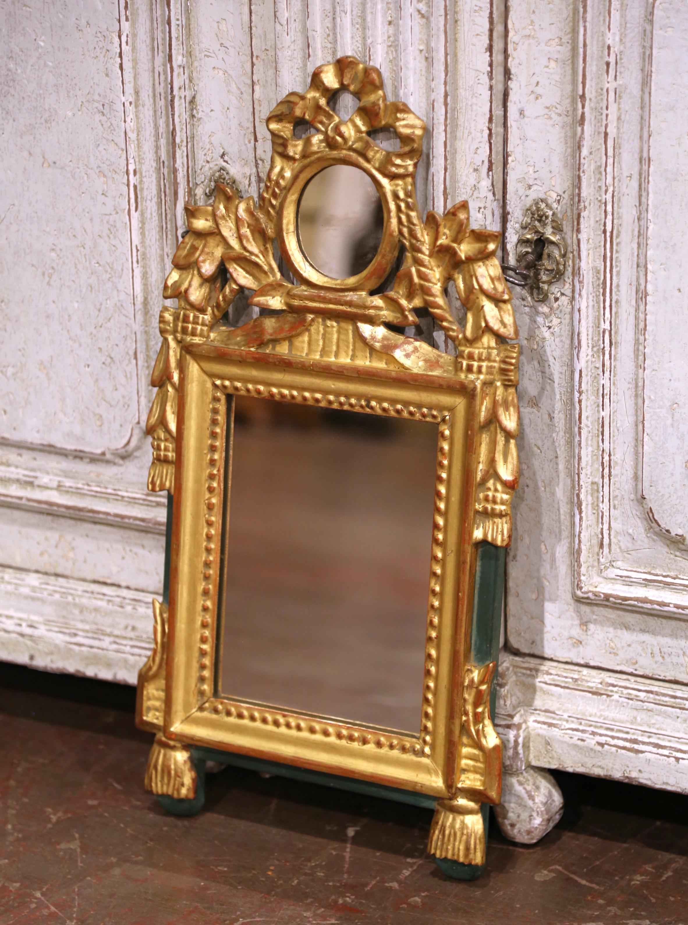 Questo specchio francese antico è stato realizzato intorno al 1880 nel raffinato stile Luigi XVI e presenta una cornice alta e stretta in legno dorato con eleganti dettagli neoclassici. La composizione è coronata da uno specchio a medaglione