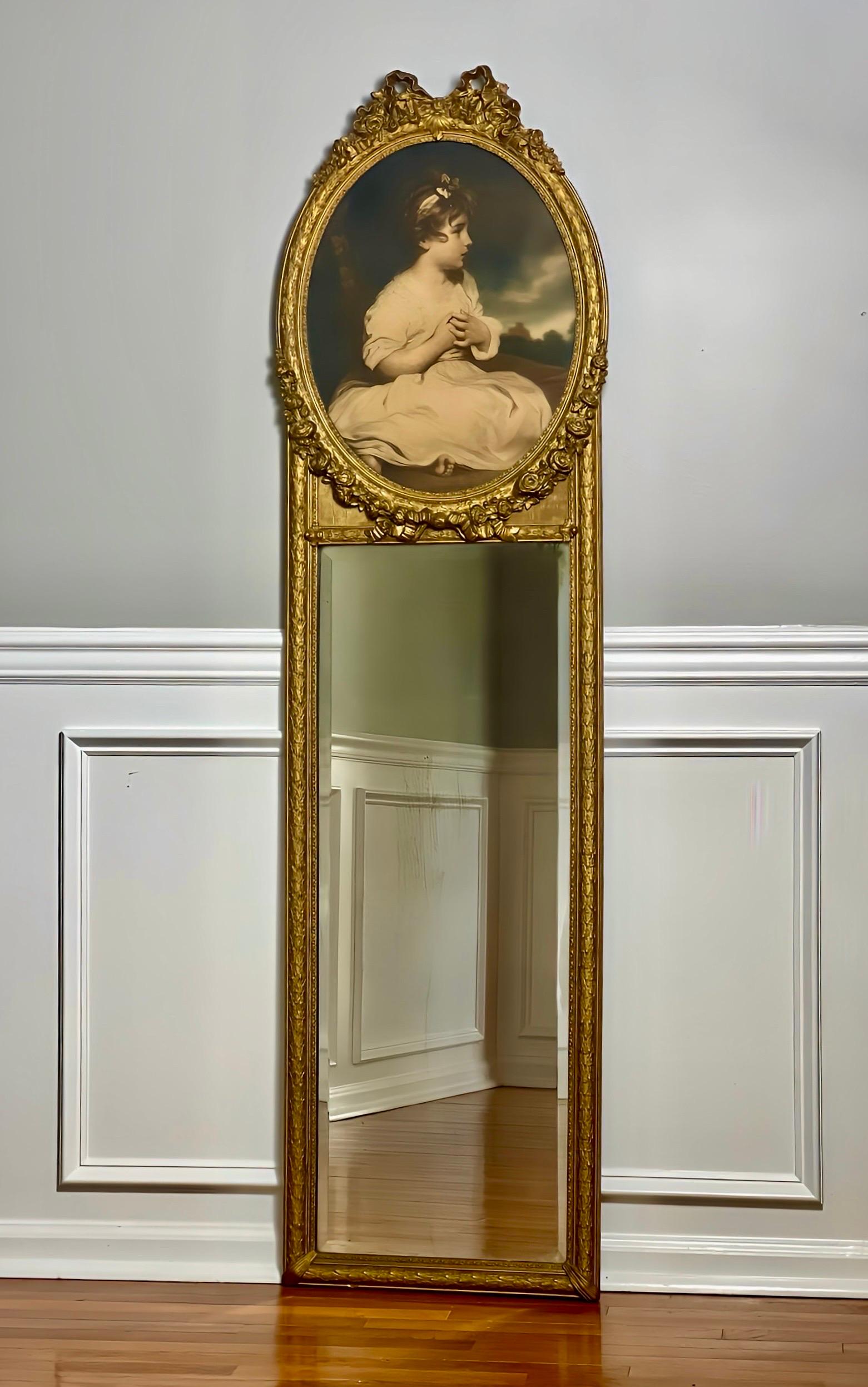 Miroir Trumeau en bois doré, mince et haut, orné d'une lithographie ovale représentant une petite fille, intitulée 