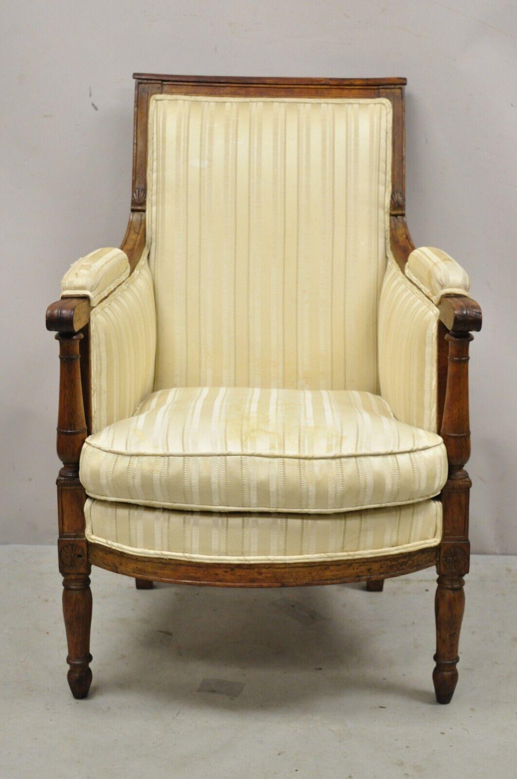 Antique 19th century French Louis XVI Neoclassical Style Walnut Bergere Club Lounge armchair. Item features a wonderful antique joinery and construction, desirable patina, solid wood frame, distressed finish, nicely carved details, tapered legs,