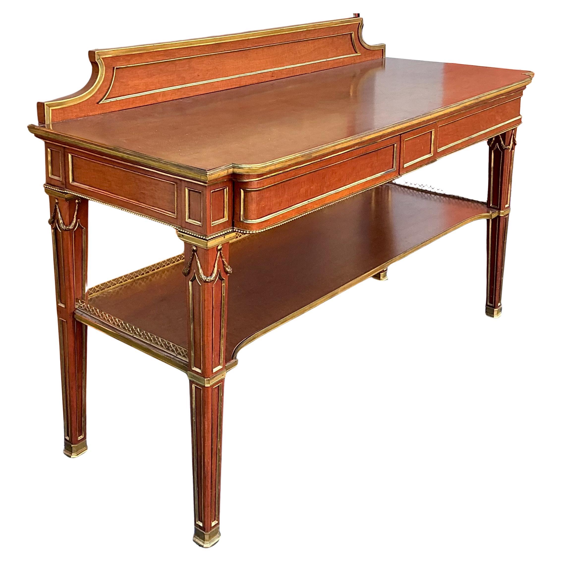 This is a spectacular piece! It is a French Louis. XVI server with gilt bronze ormolu. It is carved walnut with two drawers that have dovetail construction. The right drawer is larger and encompasses the center piece. The second tier has a gilt