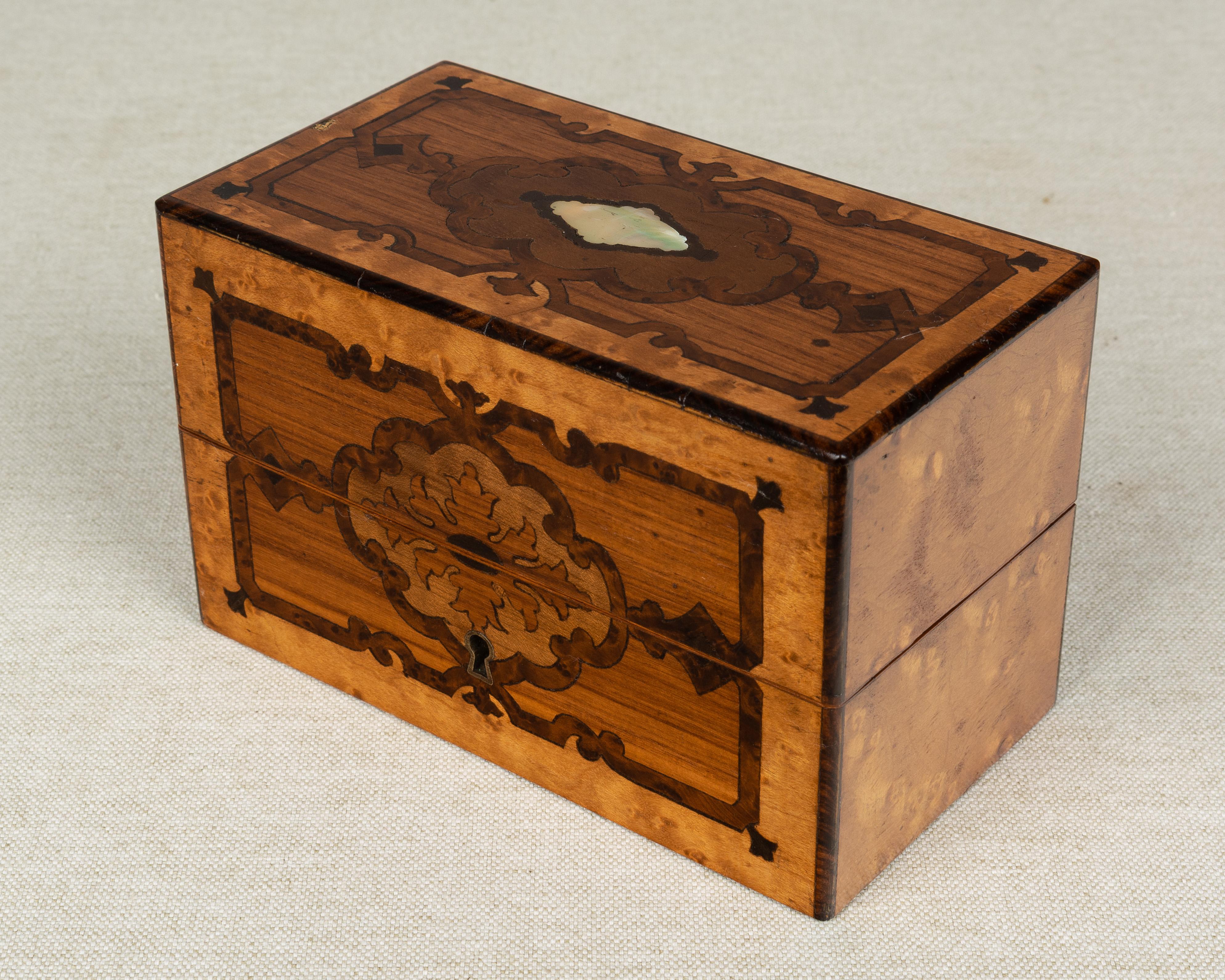 A 19th century French Napoleon III style marquetry perfume box attributed to Tahan, Paris. Made of rosewood with bird's-eye maple veneer and decorative inlay of various woods and mother of pearl. Lid has a lock and key and hinges open to reveal a