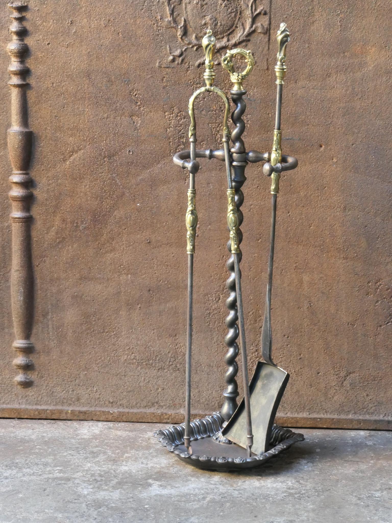Beautiful 19th century French Napoleon III fireside companion set. The tool set consists of tongs, shovel and stand. The tools and stand are made of forged iron and are finely decorated with brass details. The base of the stand is made of cast iron.