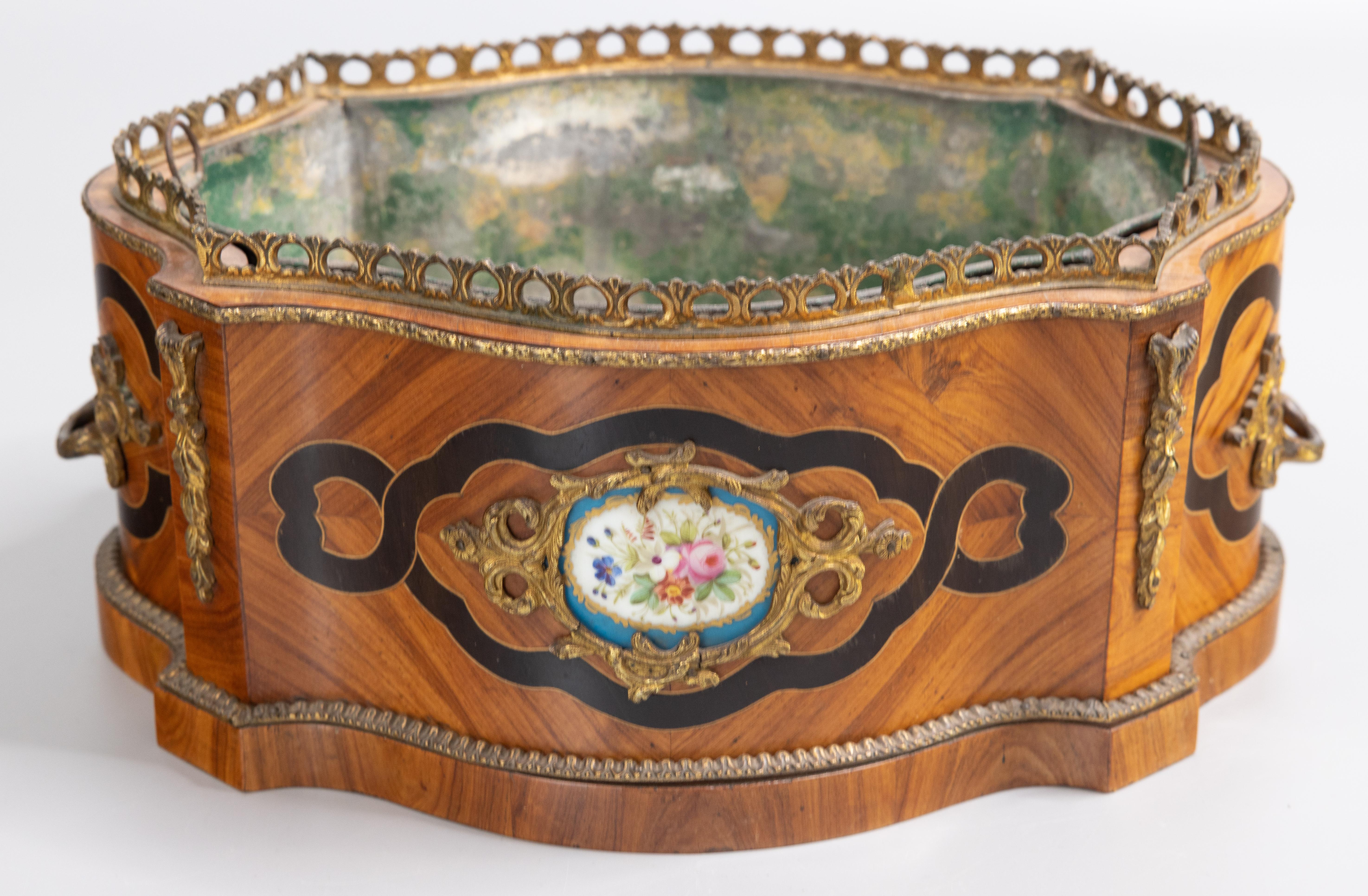 A gorgeous antique French Napoleon III period marquetry walnut oval bombe table jardiniere / bloom box / cachepot / planter with the original tin liner, circa 1860. This beautiful jardiniere is hand crafted with walnut inlaid with ebony and