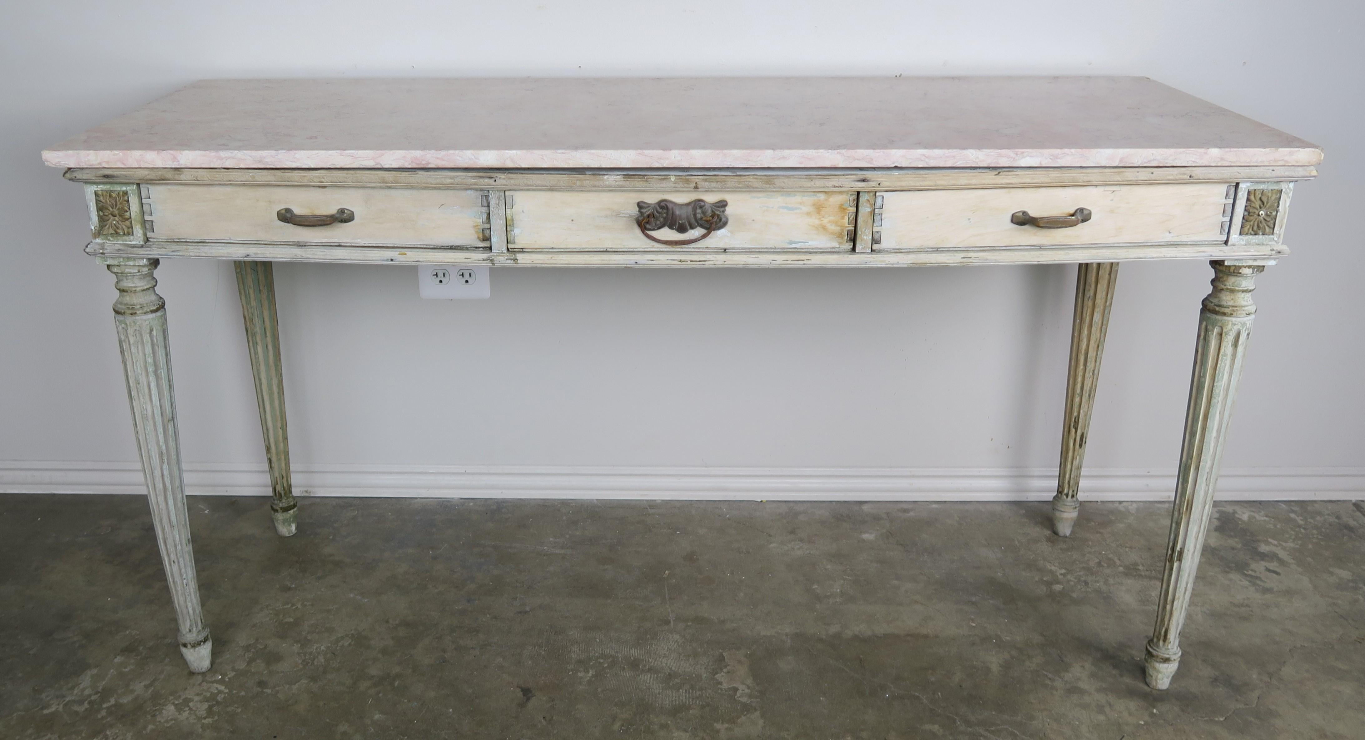 19th century French neoclassical style painted desk/writing table. The desk stand on four fluted straight legs and has three-drawer with dove-tailing. The top is a creamy rose colored marble. Original brass hardware.