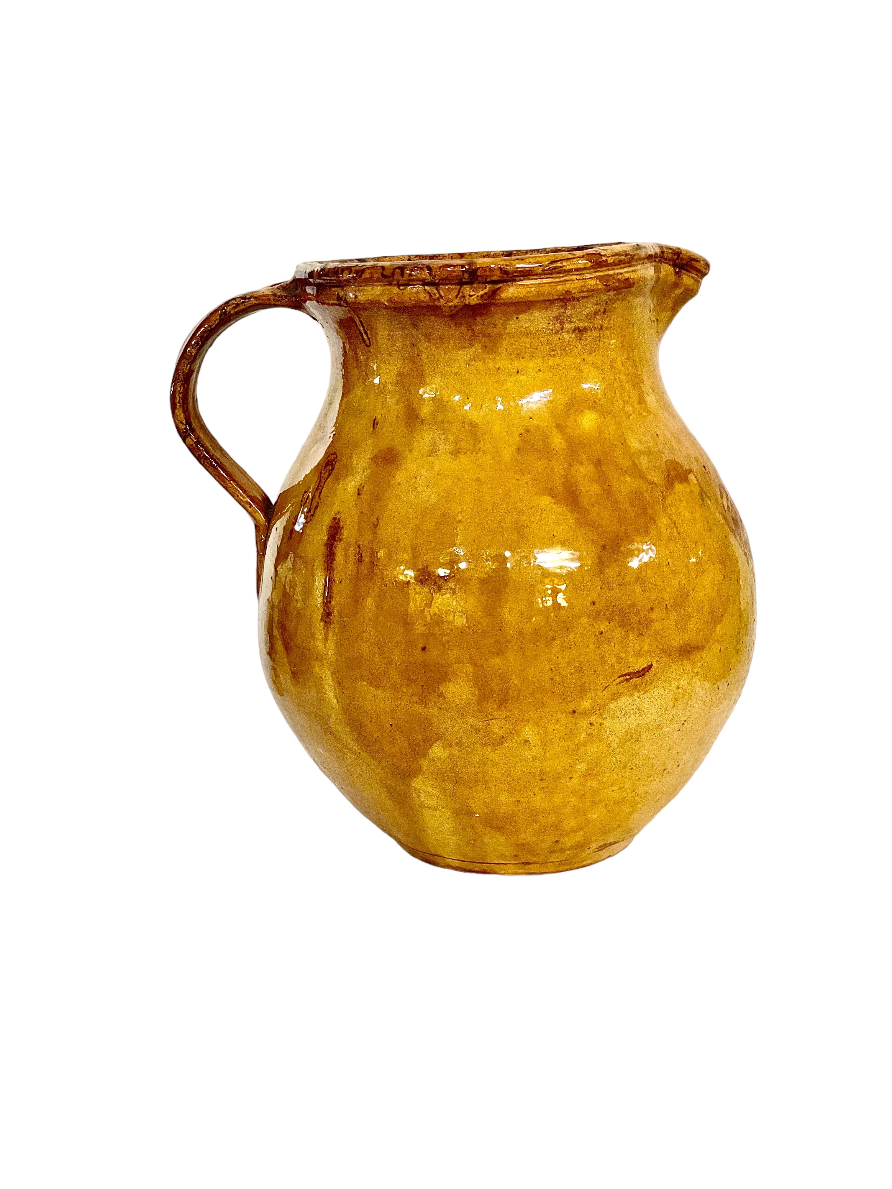 This is a beautiful example of an authentic, 19th century French water pitcher from the Provence region. Glazed internally and externally, this wonderful sunshine-yellow jug has a large side handle and pouring spout, and is sturdily built with a