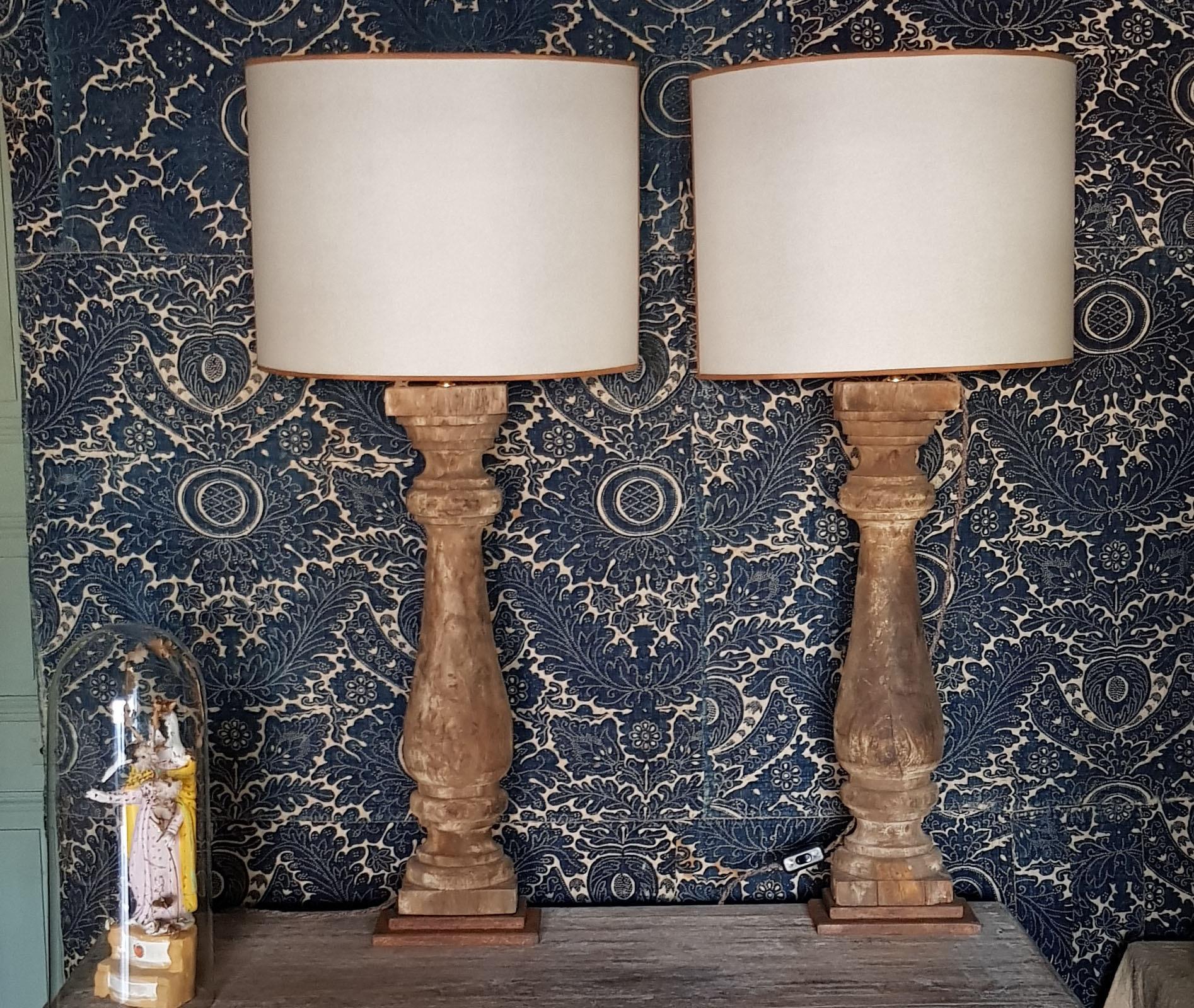 A stunning pair of tall 19th century French wood balustrade halves in original, aged patina converted to table lamps. The lamp bases are made of iron and the lamp shades parchment. Lovely French braided cords, newly electrified for use in the U.S. 