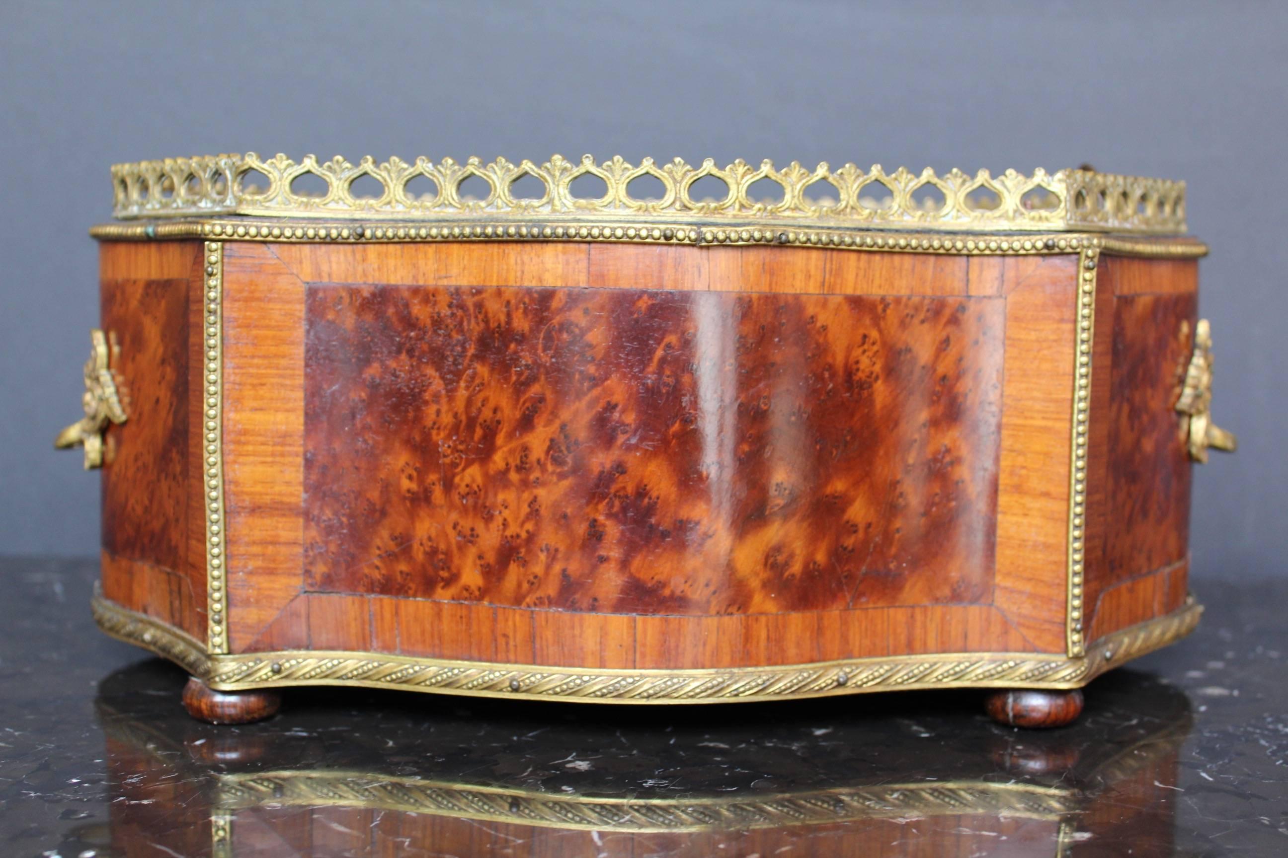 Elegant with its violin shape Napoleon III planter featuring a gilded bronze gallery at top, rows of gilded brass pearls and pair of handles. Great patinated burr walnut marquetry on all sides. Rest on four small wooden bun feet. Comes with its