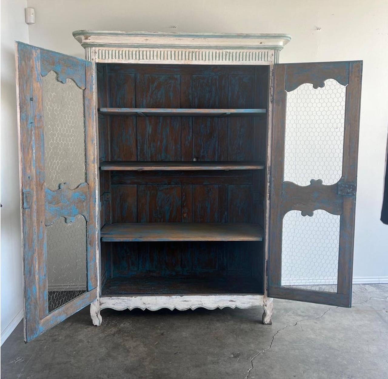 Armoire francese del XIX secolo dipinto con filo di ferro.  L'armadio è dipinto nei toni dell'acqua marina e del bianco antico.  È possibile vedere anche il legno sottostante. 
Ci sono due ante che nascondono tre ripiani: c'è un sacco di spazio. 