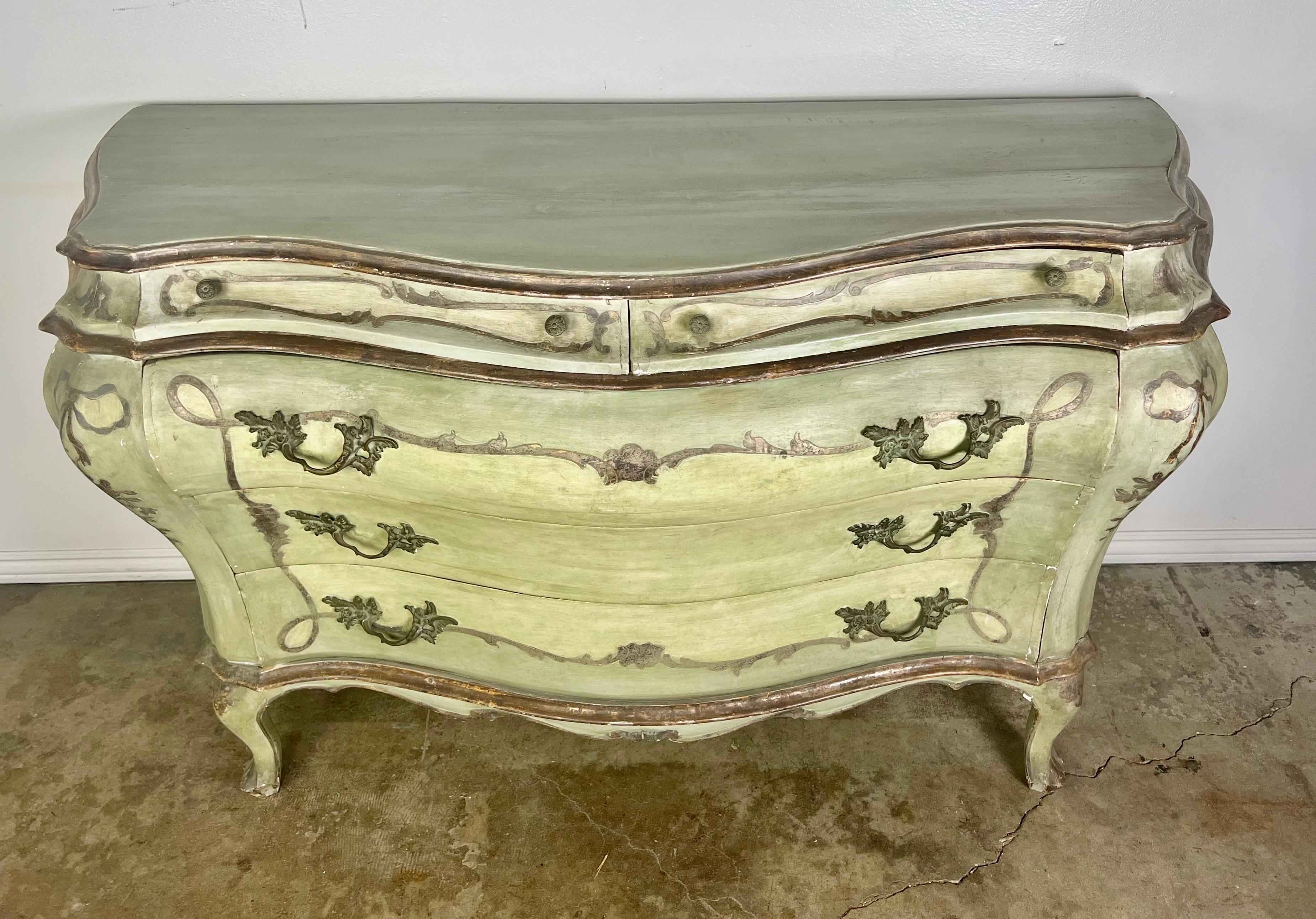 19th C. French Louis XV style commode. The original green painted and parcel gilt finish depicts bows and ribbon throughout. The Commode has five drawers with plenty of storage space. Wear is consistent with age but the paint is intact.