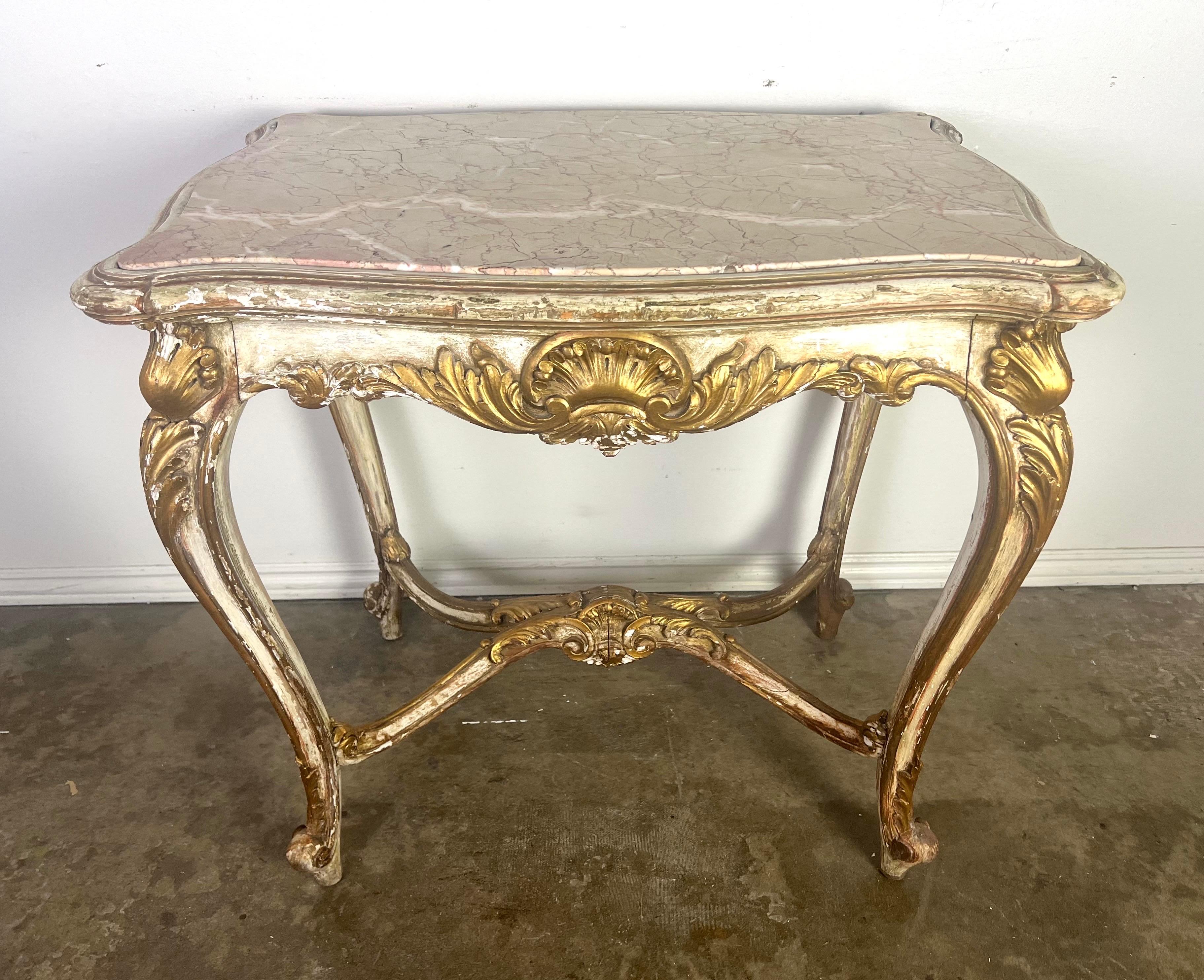 19th Century French Rococo style white colored painted & parcel gilt table. The Rococo style flourished in Europe, particularly in France, during the early to mid 18th century.   Rococo design is known for its ornate and intricate details of