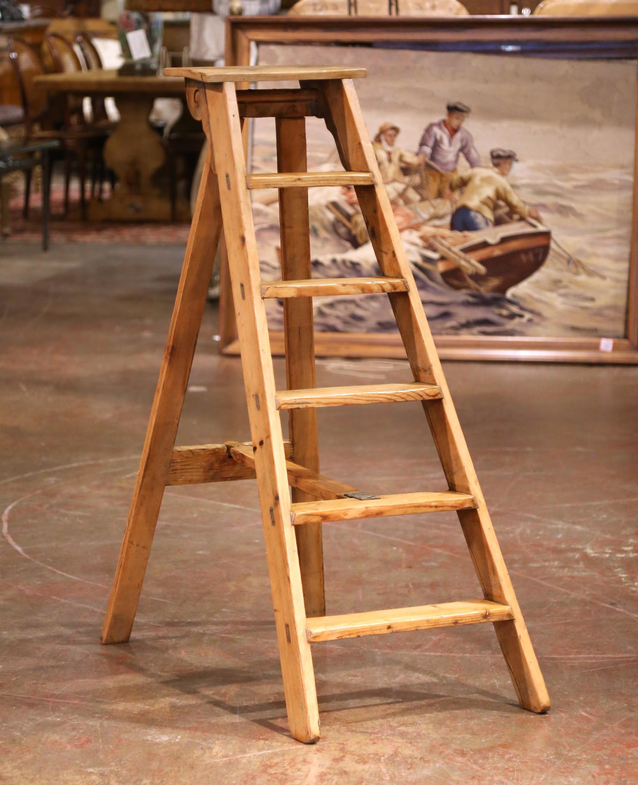 Crafted in France in the late 19th century, this charming six-step folding ladder offers both utility and timeworn character. Built from solid pine with visible pegged joinery and iron hardware, the ladder showcases traditional craftsmanship and a