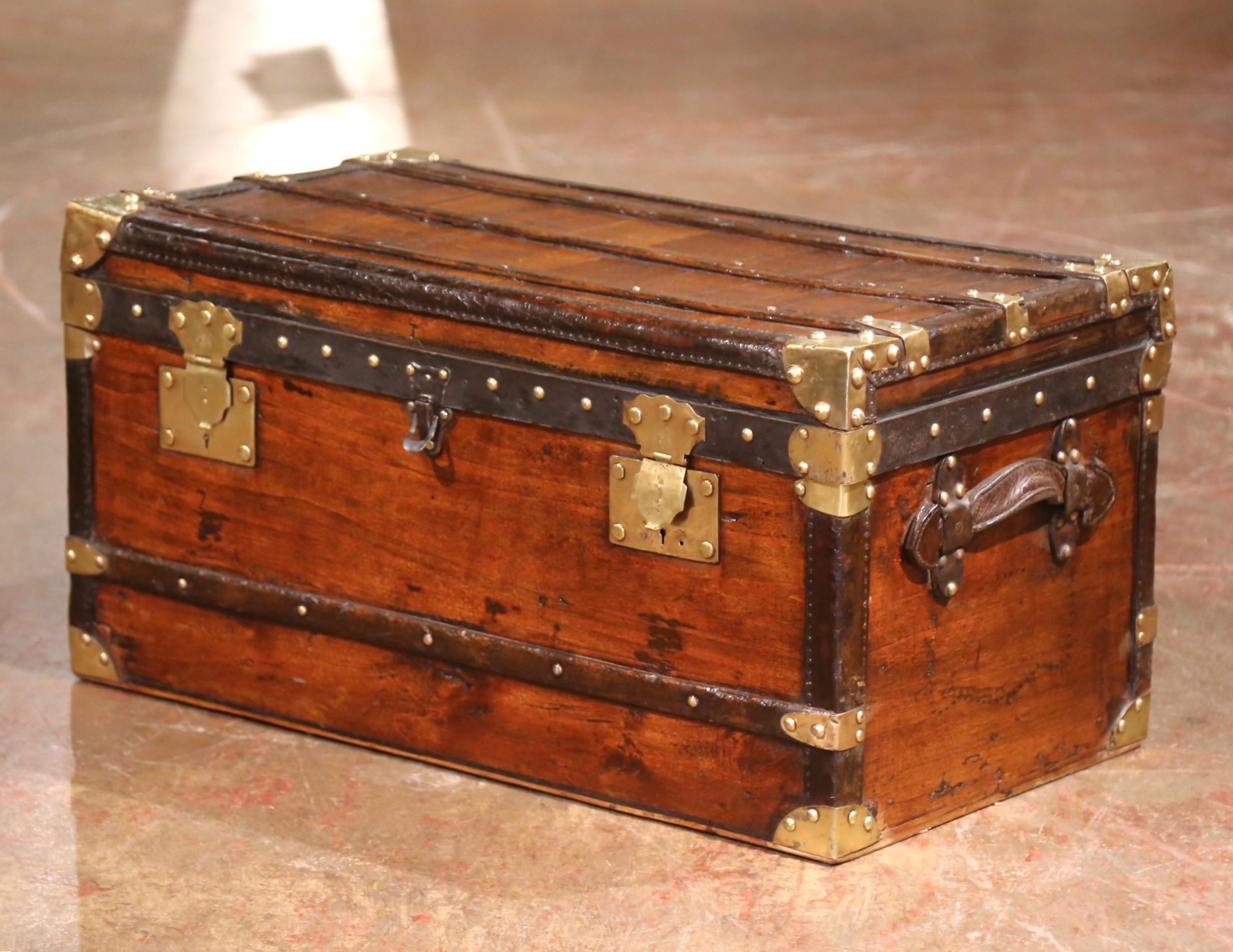 Crafted in France circa 1895, this striking late 19th-century travel trunk is built from richly patinated poplar and features bold black iron strapping, brass hardware, and corner guards. The lockplate is stamped B.B. Paris with the inscription
