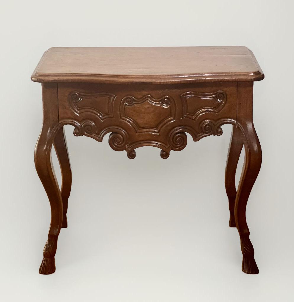 French Provincial Louis XV style carved walnut table with drawer, c. 1890.

From the Fourques region in the South of France, this beautiful table features a curvilinear top over a single, wide drawer with hand dovetail construction and elegantly