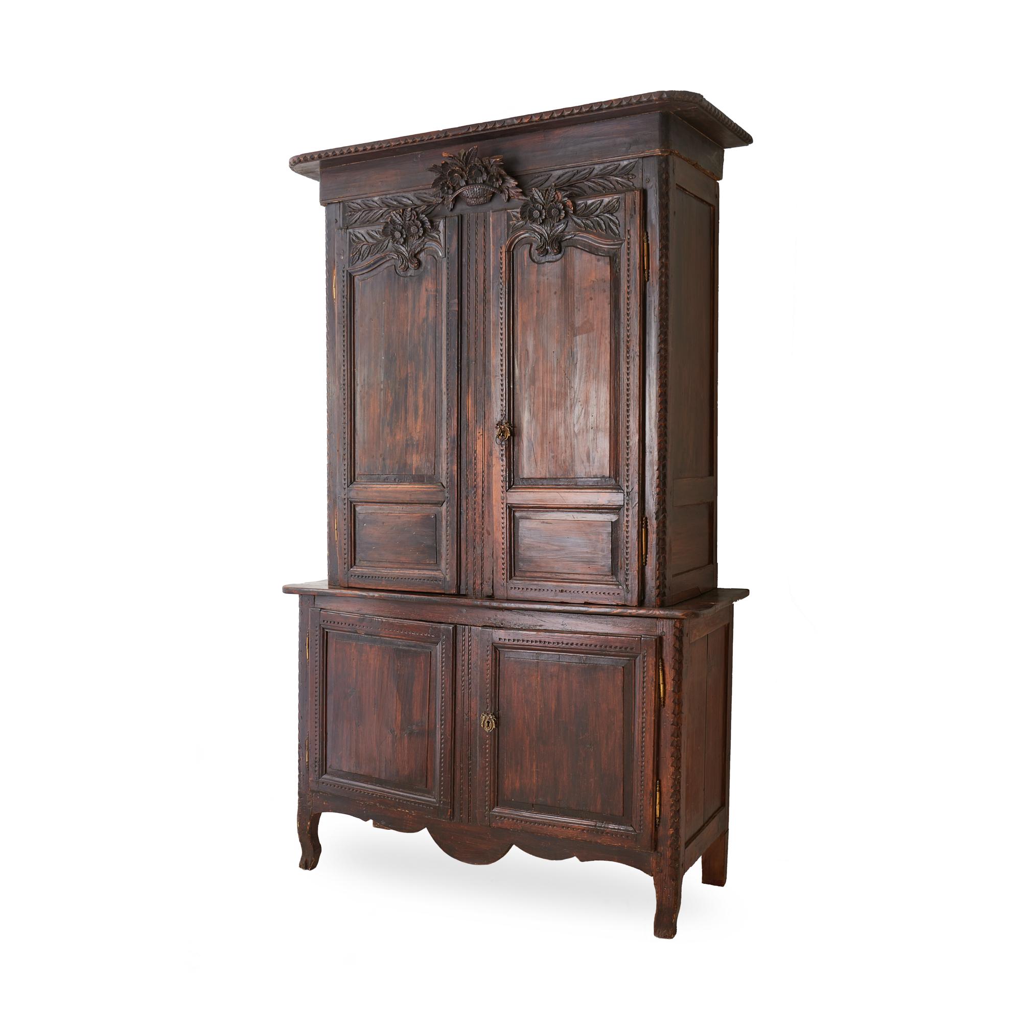 Early 19th century French Provincial oak deux corps cabinet, with decorative floral carvings throughout. Two pieces, with upper portion resting atop wider base - the two pieces would need to be secured into place once they reach their final