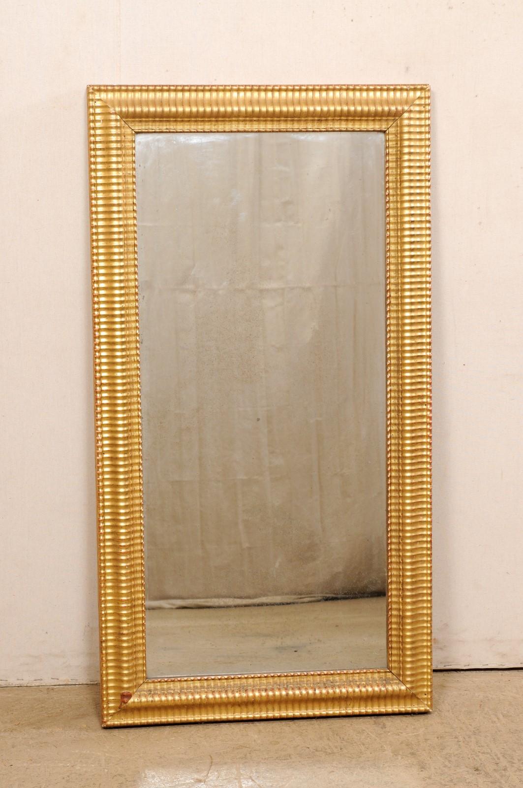 Ein französischer geschnitzter und vergoldeter rechteckiger Wandspiegel aus dem 19. Jahrhundert. Dieser antike Spiegel aus Frankreich hat einen rechteckigen Rahmen mit einem sich wiederholenden Rippenmuster, das ihm eine subtile Bewegung und