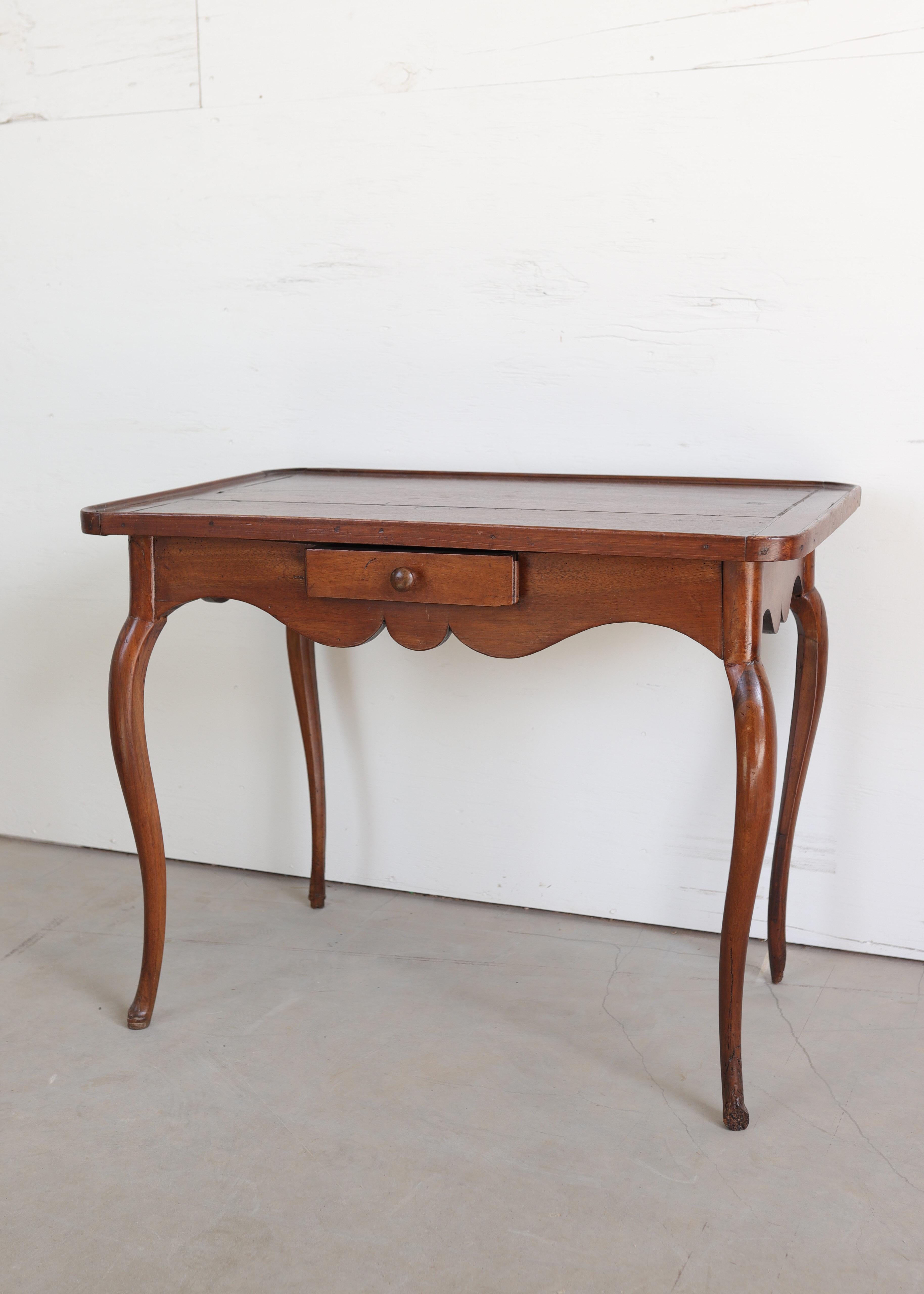 Une charmante table provinciale française du 19e siècle fabriquée à la main en noyer riche et chaud avec une patine magnifiquement vieillie. Le plateau rectangulaire présente en son centre une subtile incrustation en forme de diamant, encadrée par