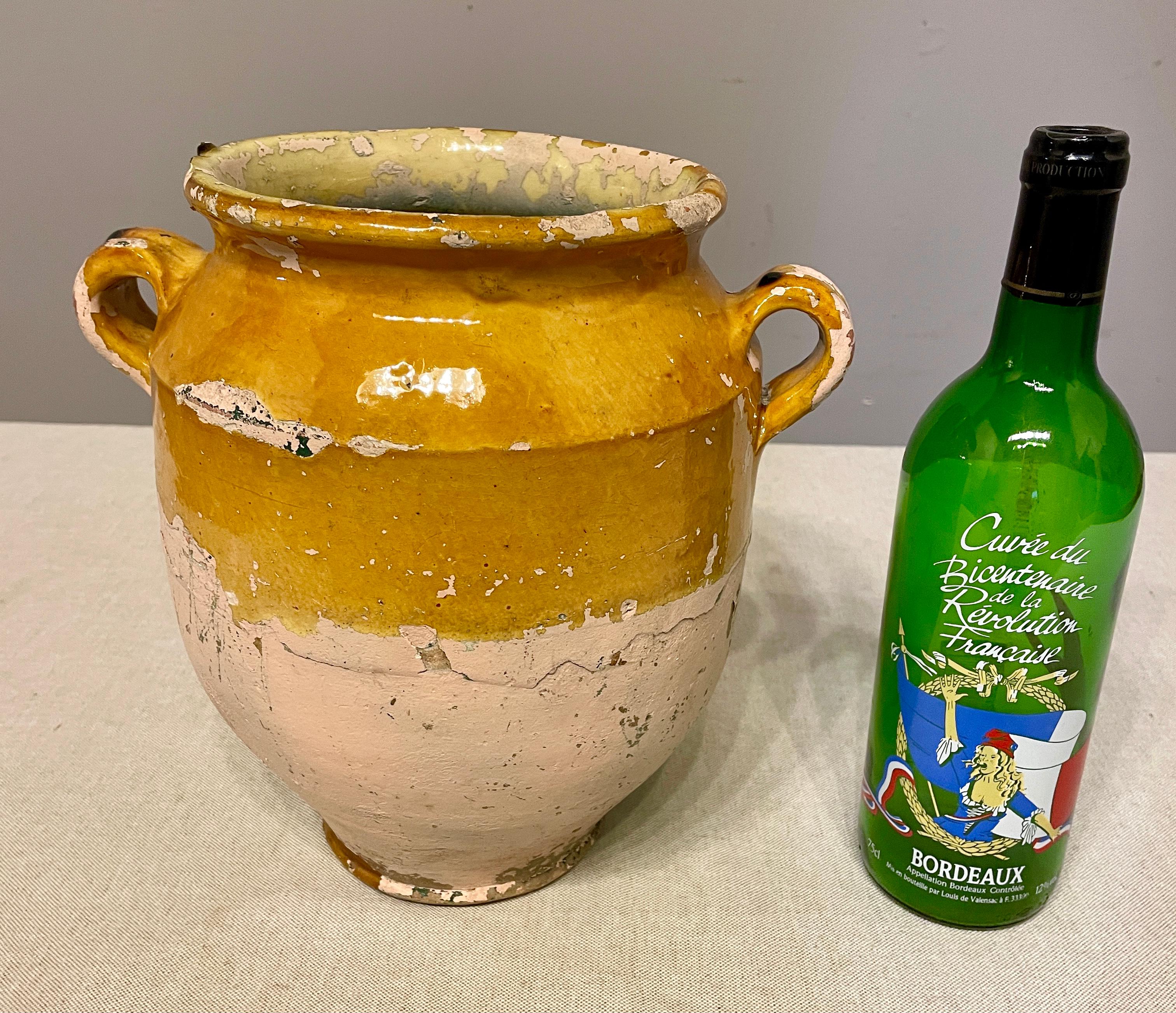 An earthenware confit pot from the Southwest of France with traditional yellow glaze. Some chips and losses to glaze. Sign of old paint. Stamped initials 