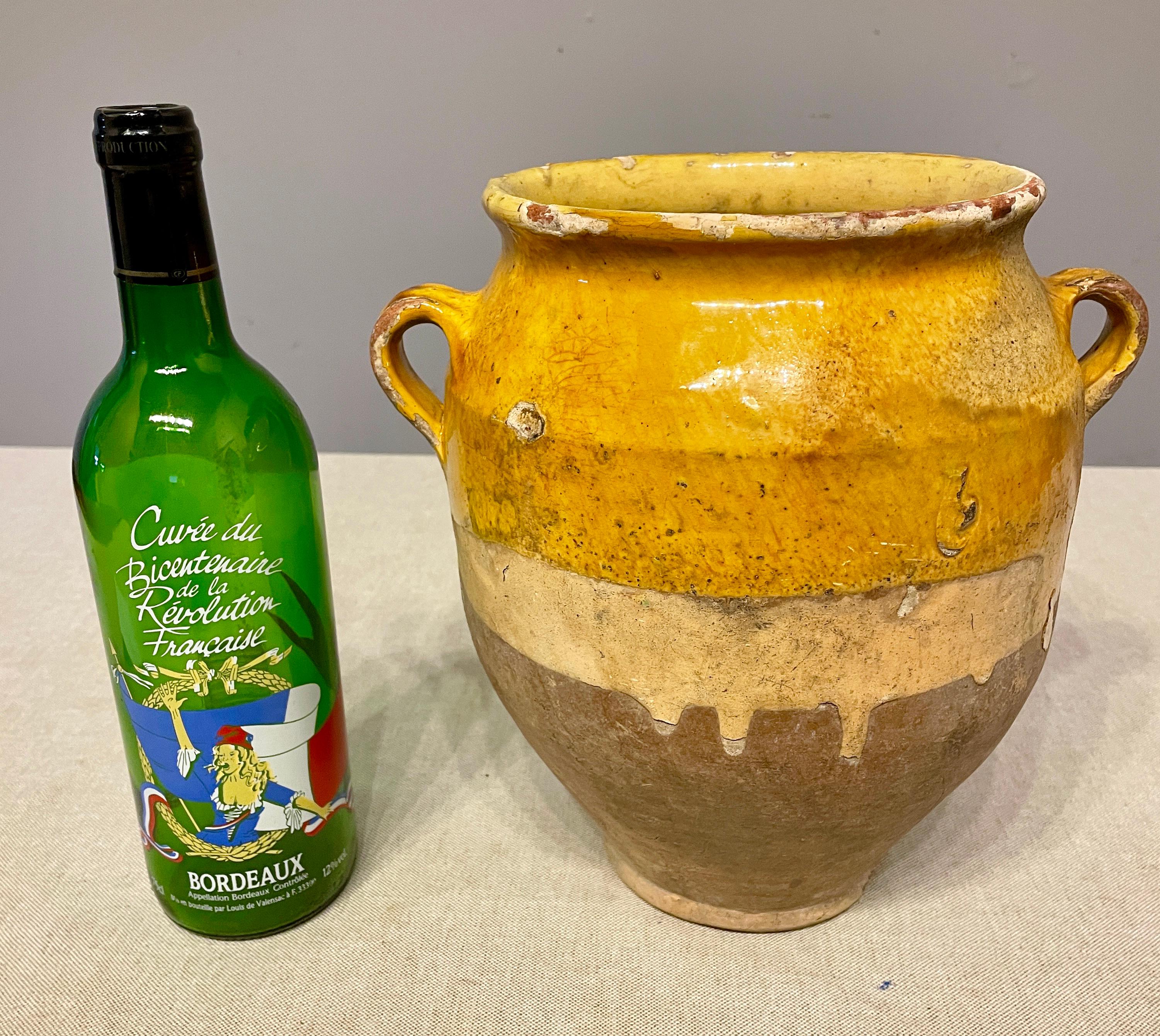 An earthenware confit pot from the Southwest of France with traditional yellow, ochre glaze. Some chips and losses to glaze. These ordinary earthenware vessels were once used daily in the French country home and have beautiful rustic glazes of